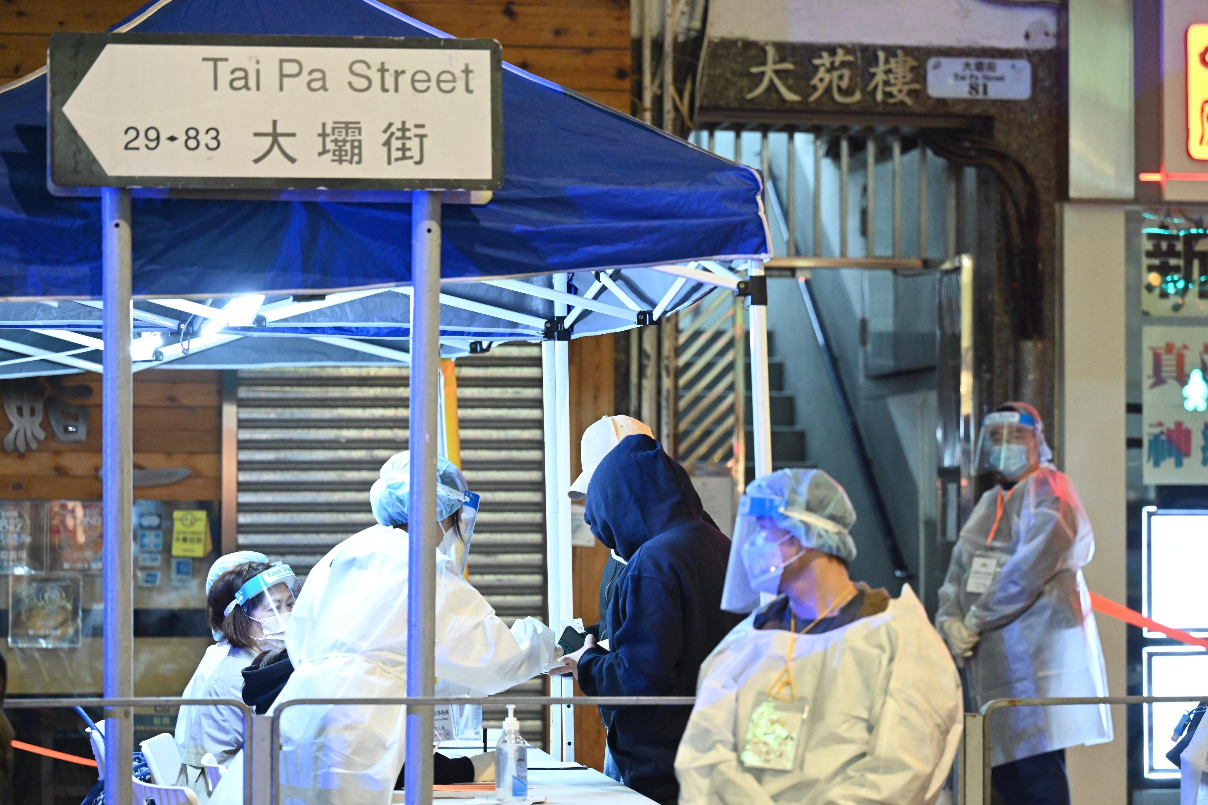 The Government yesterday (January 28) made a "restriction-testing declaration" and issued a compulsory testing notice in respect of the specified "restricted area" in Tsuen Wan (i.e. Tai Yuen House, 77-83 Tai Pa Street, Tsuen Wan, excluding the shops located on the ground floor of Tai Yuen House), under which people within the specified "restricted area" in Tsuen Wan were required to stay in their premises and undergo compulsory testing. Photo shows staff members registering persons subject to compulsory testing in the "restricted area" to undergo testing.