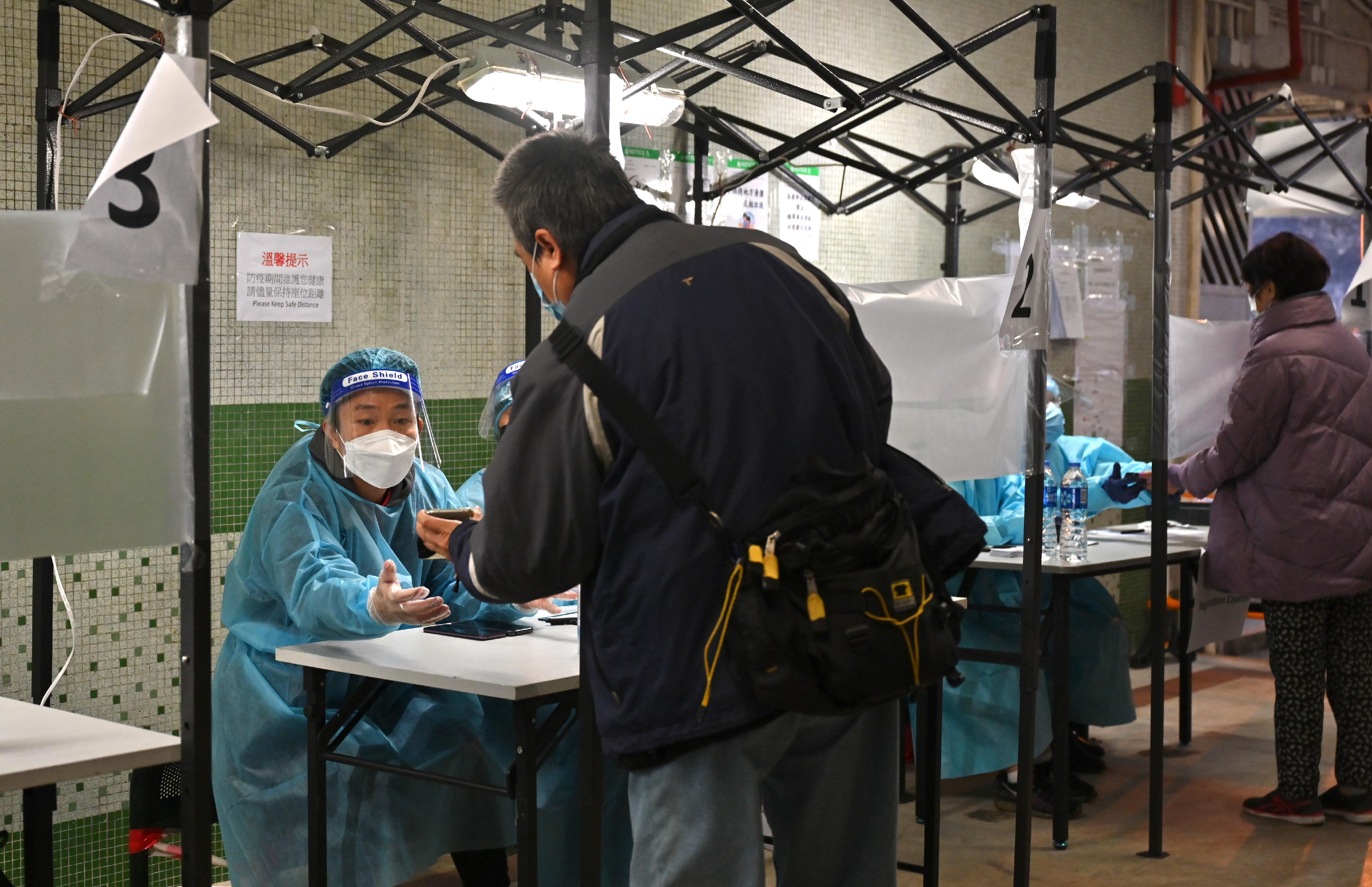 The Government yesterday (February 1) made a "restriction-testing declaration" and issued a compulsory testing notice in respect of Tung Moon House, Tai Hang Tung Estate. Photo shows staff members of the Housing Department checking whether persons in the "restricted area" have undergone compulsory testing in the enforcement operation.