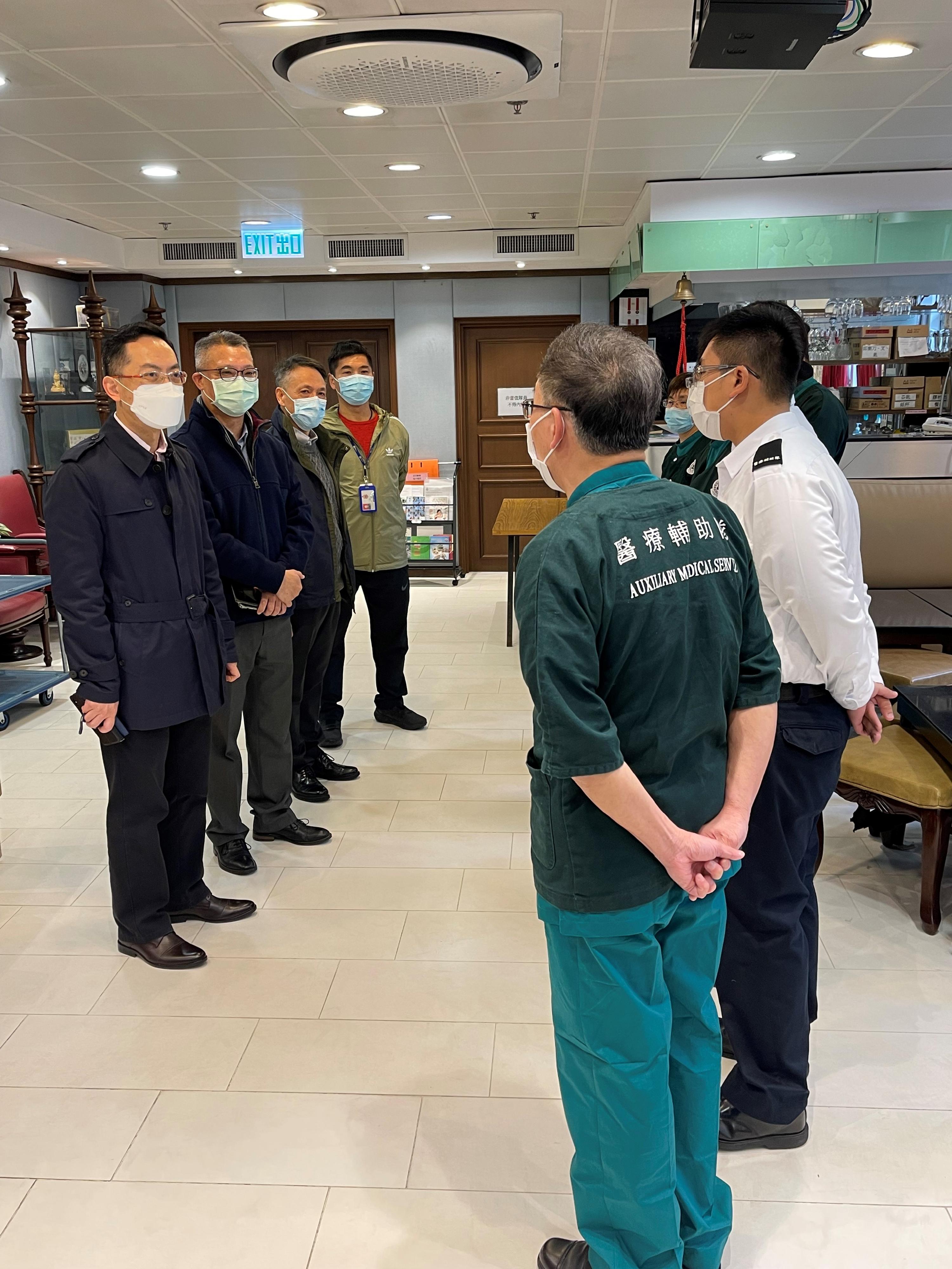 The Commissioner of the Auxiliary Medical Service (AMS), Dr Ronald Lam, today (February 2) visited colleagues on duty at the AMS Headquarters in Ho Man Tin. Photo shows Dr Lam (first left), accompanied by the Chief Staff Officer of the AMS, Mr Wong Ying-keung (second left), listening to AMS members' briefing on their daily work.