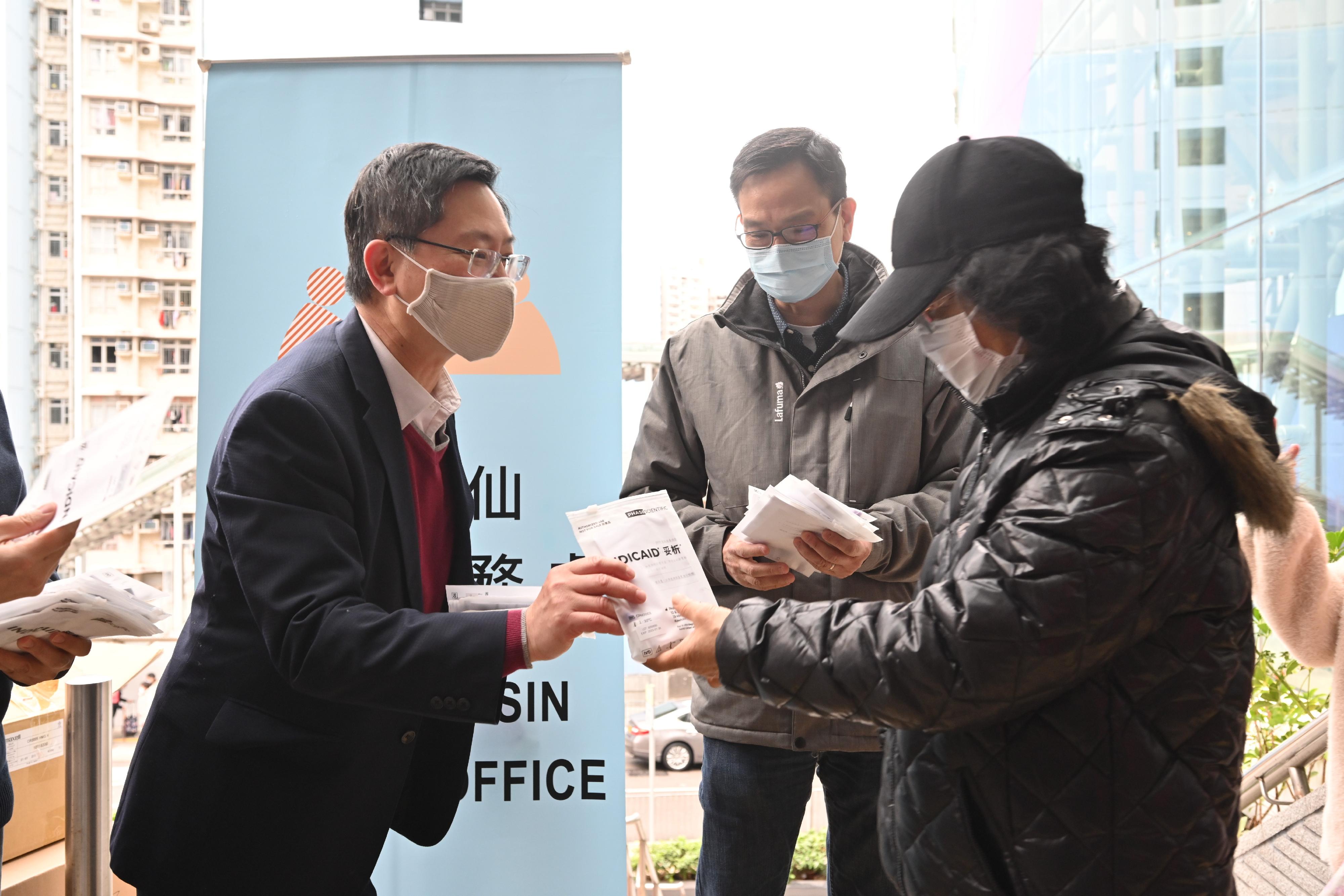 The Secretary for Innovation and Technology, Mr Alfred Sit (first left),distributes COVID-19 rapid test kit at Tsz Wan Shan Shopping Centre today (February 3) and calls on residents to undergo voluntary testing and help fight the virus together.