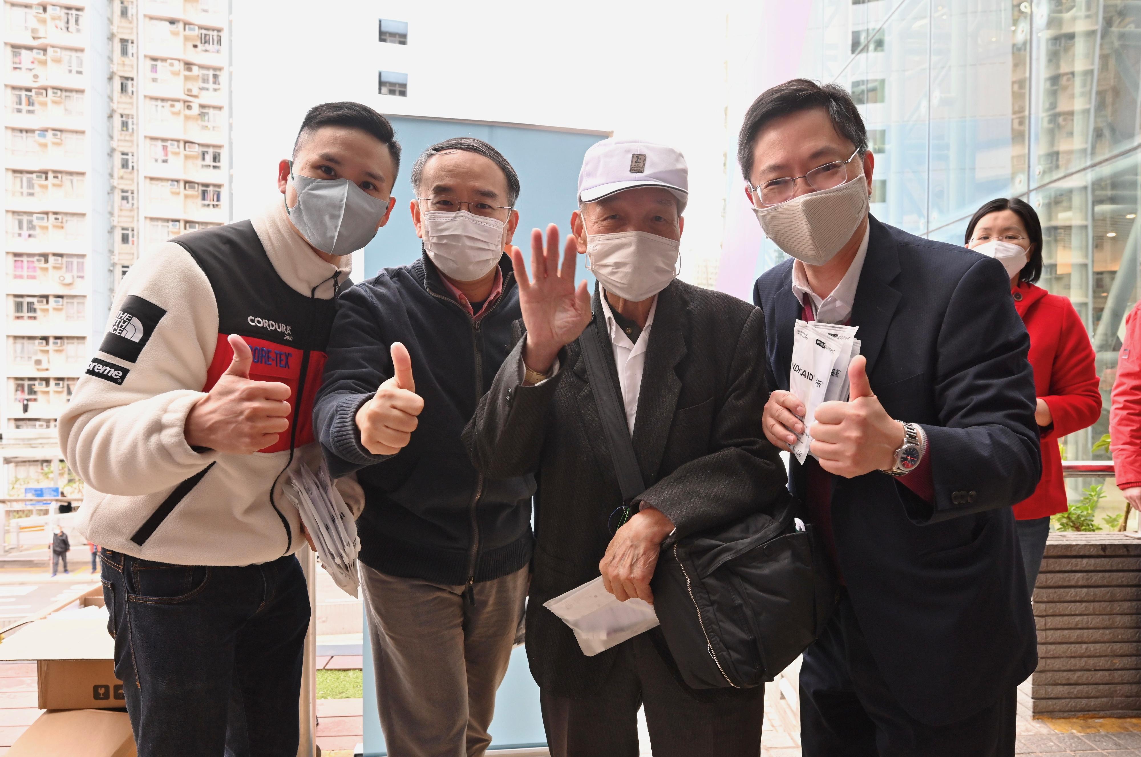The Secretary for Innovation and Technology, Mr Alfred Sit (first right), and the Secretary for Financial Services and the Treasury, Mr Christopher Hui (second left) participate in an activity organised by the Wong Tai Sin District Office to distribute COVID-19 rapid test kit at Tsz Wan Shan Shopping Centre today (February 3). Looking on is the District Officer (Wong Tai Sin), Mr Steve Wong (first left). 