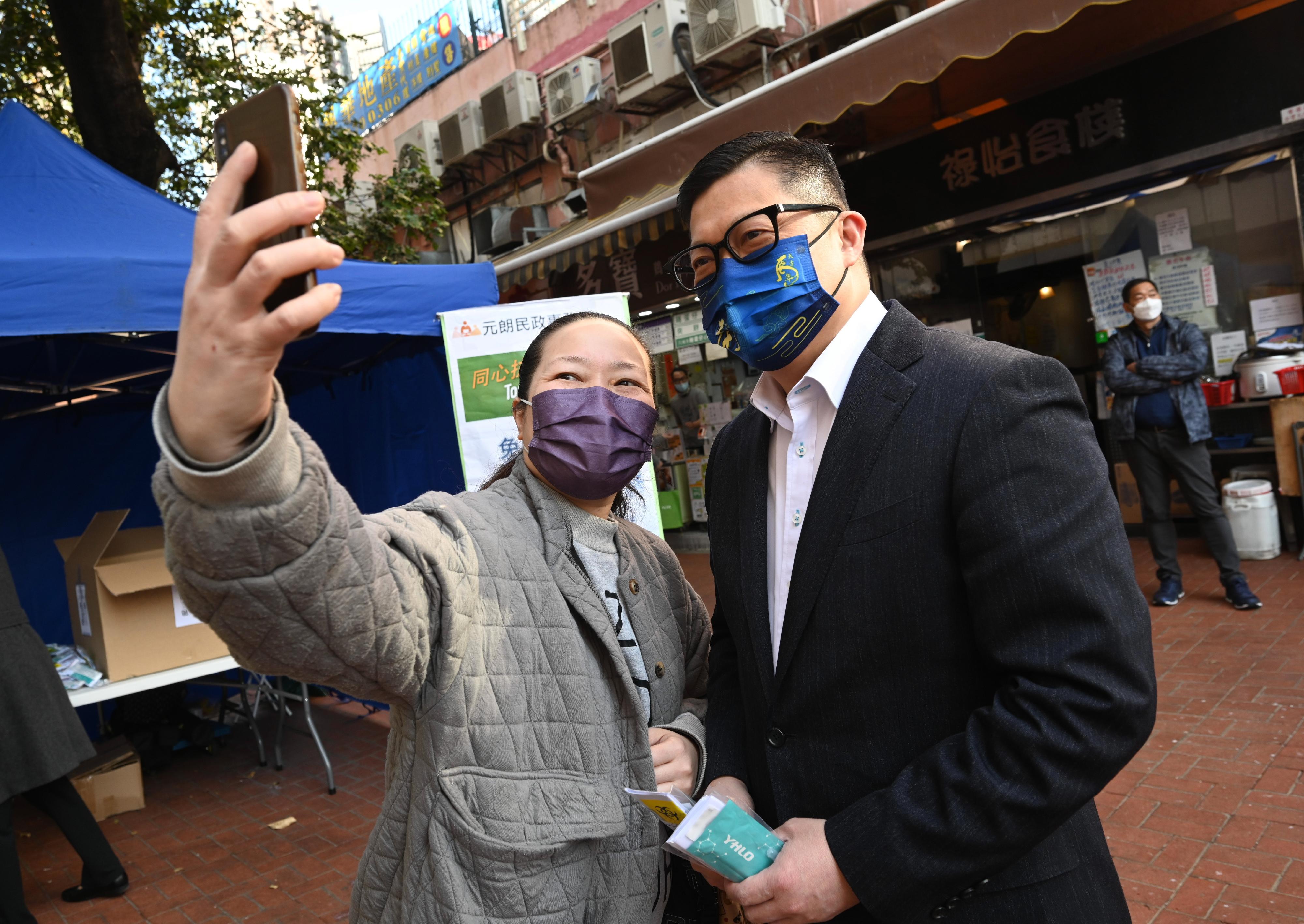 The Secretary for Security, Mr Tang Ping-keung (first right), distributed COVID-19 rapid test kits at On Tat Square in Yuen Long today (February 4) and called on residents to undergo voluntary testing and help fight the virus together. Photo shows Mr Tang joining a photo with a resident who received a COVID-19 rapid test kit.