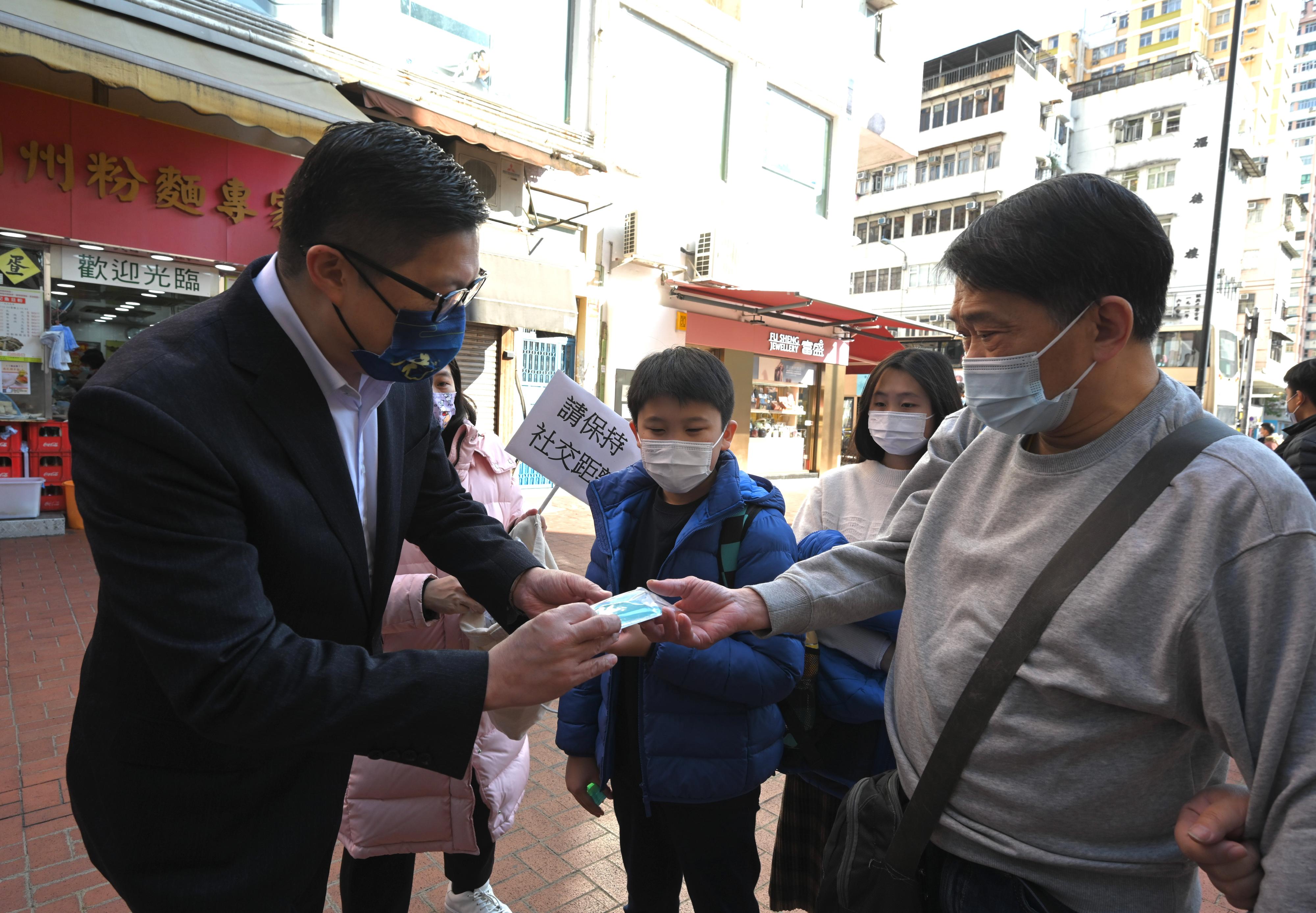 保安局局長鄧炳強（左一）今日（二月四日）元朗安達坊派發2019冠狀病毒病快速測試套裝，呼籲市民願檢盡檢，同心抗疫。