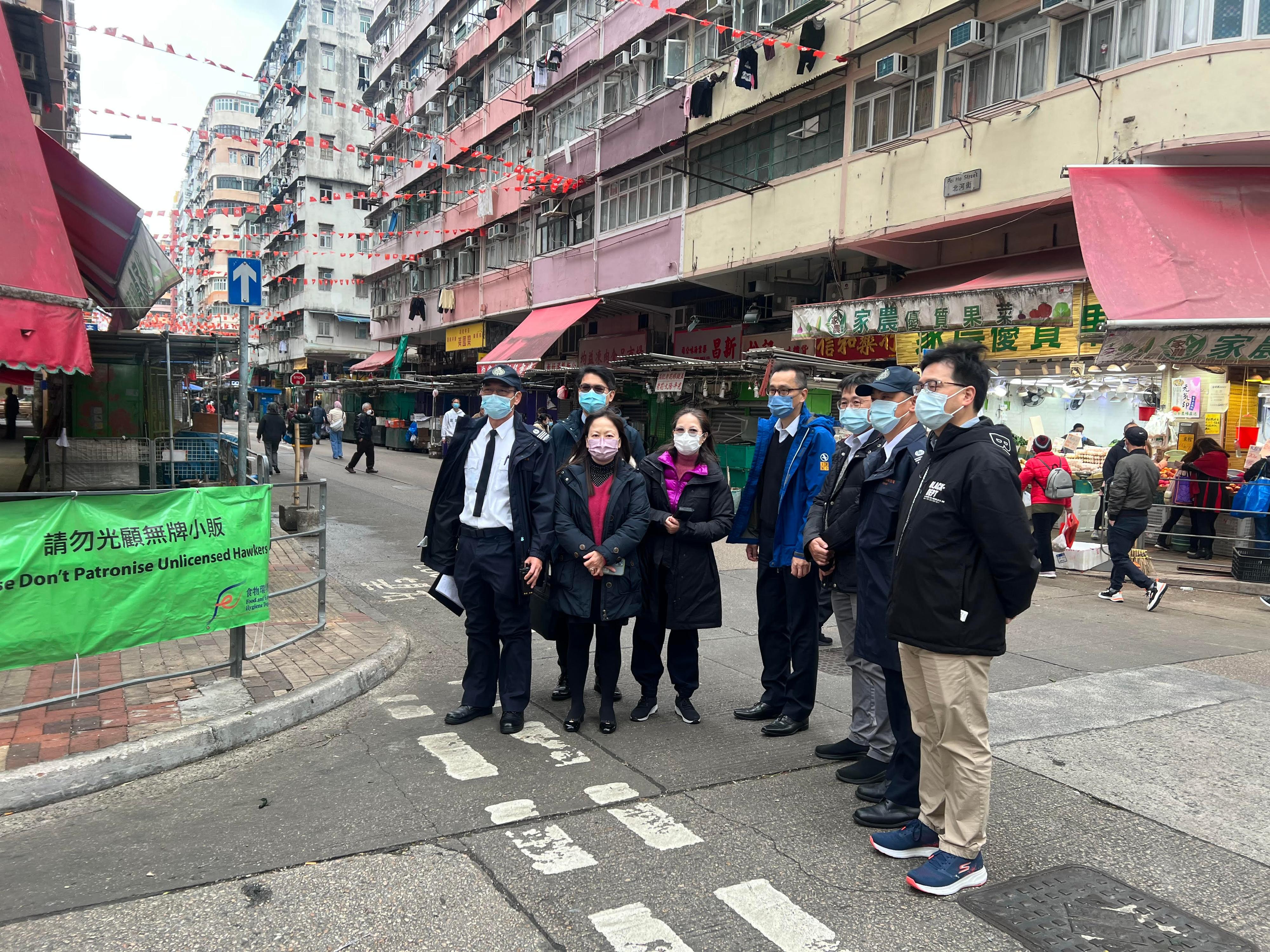 To keep passageways clear, the Food and Environmental Hygiene Department stepped up inspections and enforcements at the streets around Pei Ho Street Market area in Sham Shui Po. Photo shows Deputy Director of Food and Environmental Hygiene, Miss Diane Wong (fourth left) inspecting the vicinity of Pei Ho Street Market during the Lunar New Year. 