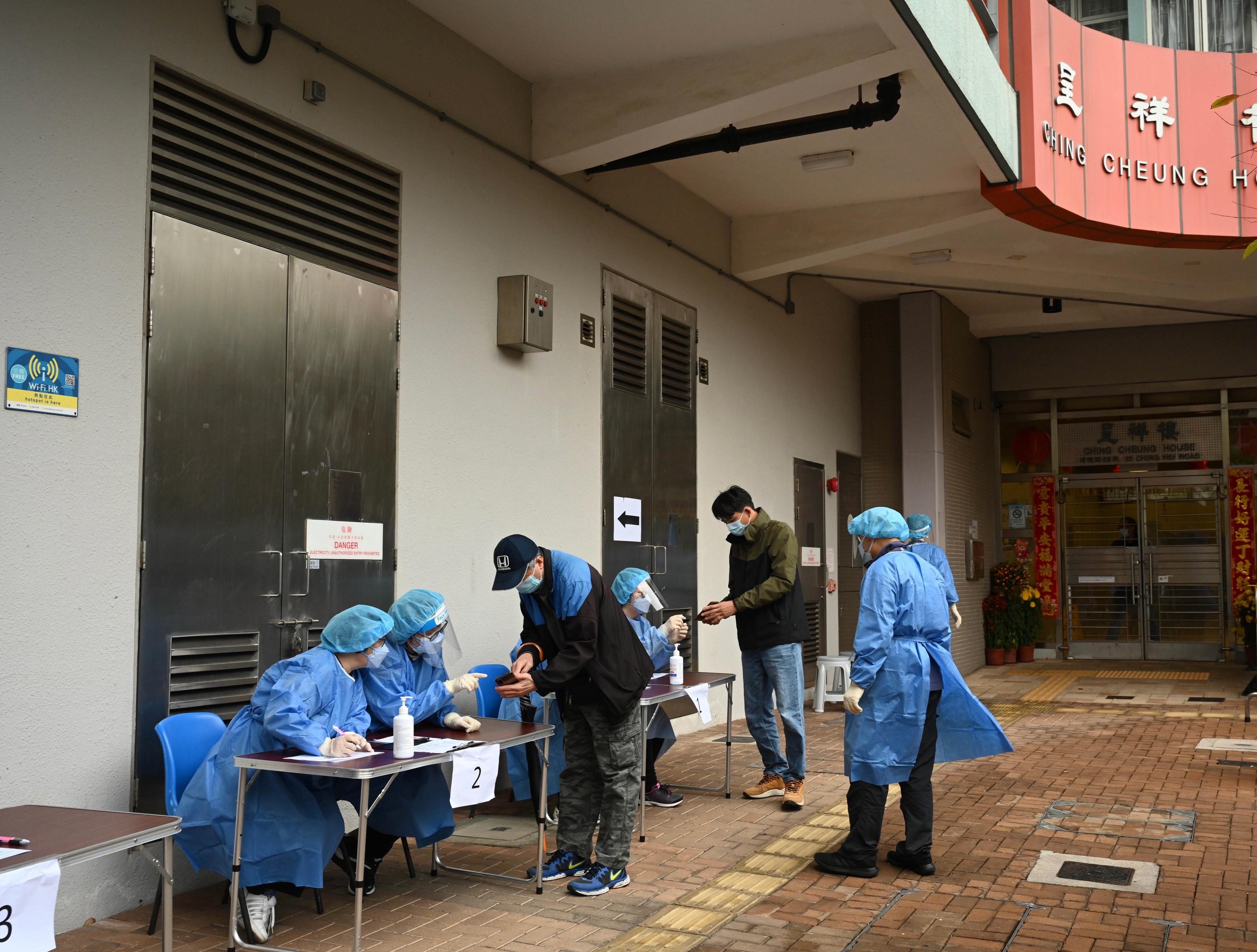 The Government yesterday (February 12) made a "restriction-testing declaration" and issued a compulsory testing notice in respect of Ching Cheung House, Cheung Lung Wai Estate. Photo shows staff members of the Housing Department today (February 13) checking whether persons in the "restricted area" have undergone compulsory testing in the enforcement operation.
