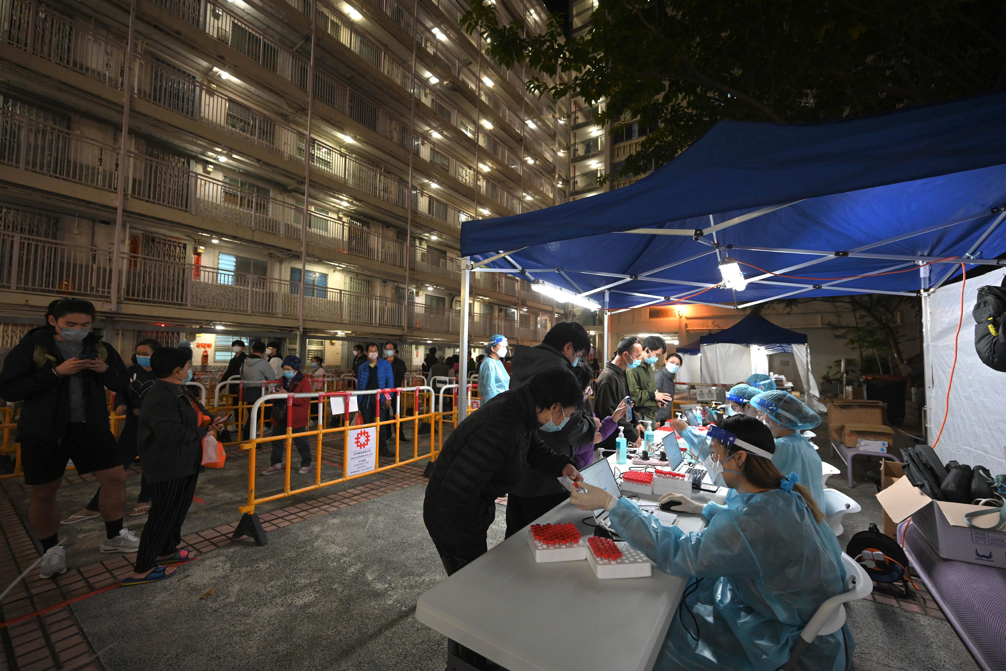 政府昨日（二月十四日）就香港仔華富（一）邨華裕樓作出限制與檢測宣告及強制檢測公告。圖示受影響人士獲安排準備接受檢測。