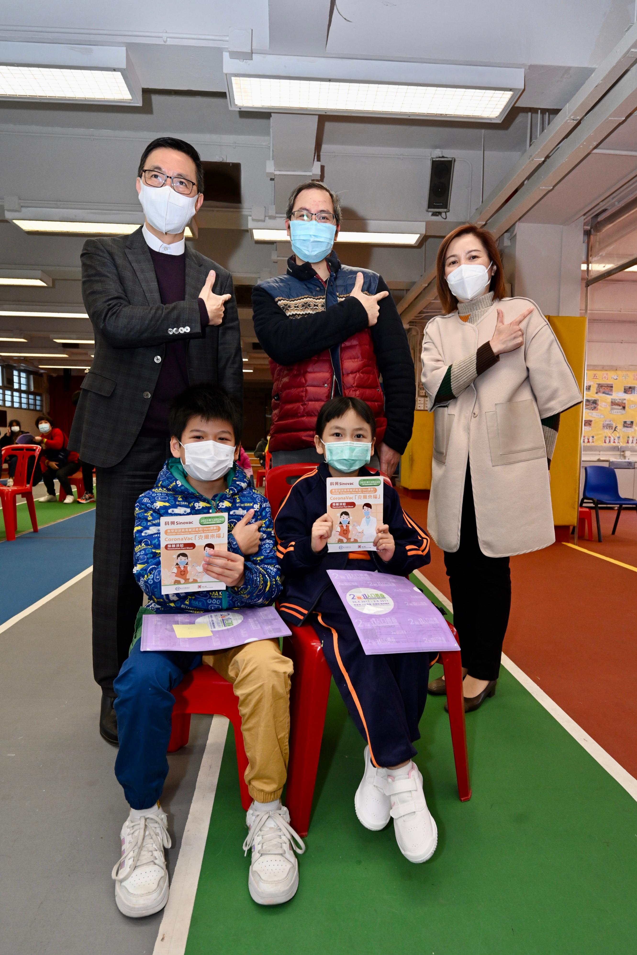 The Secretary for Education, Mr Kevin Yeung, visited Shau Kei Wan Government Primary School today (February 25) to inspect the implementation of the Vaccination Subsidy Scheme School Outreach. Picture shows Mr Yeung (back row, first left), together with the Headmistress, Ms Leung Ching-yee (back row, first right), a parent and students, appealing to students to receive vaccination as soon as possible.
