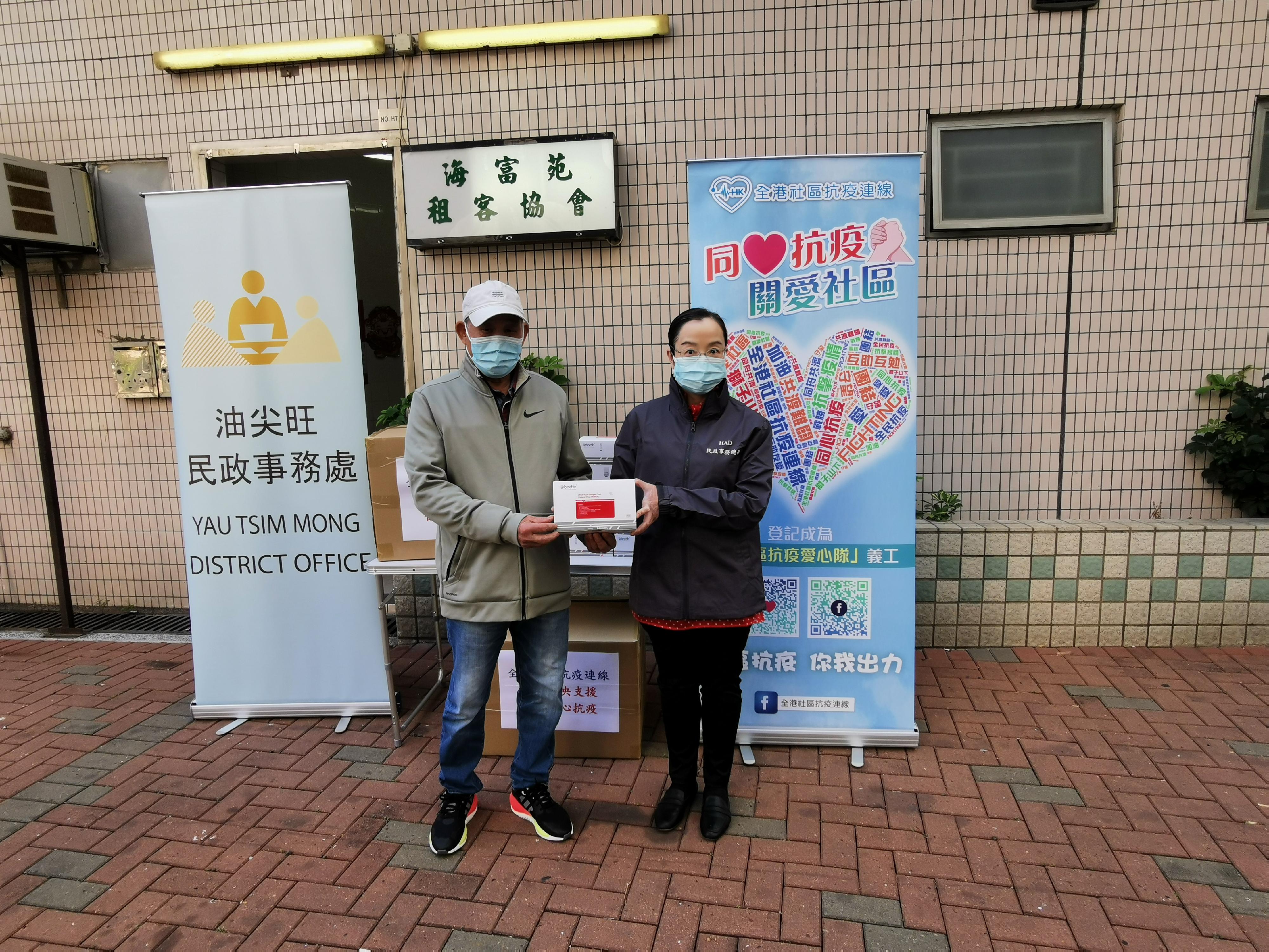The Acting Director of Home Affairs, Miss Vega Wong (right), distributed COVID-19 rapid test kits to Yau Tsim Mong residents at Hoi Fu Court on February 27.