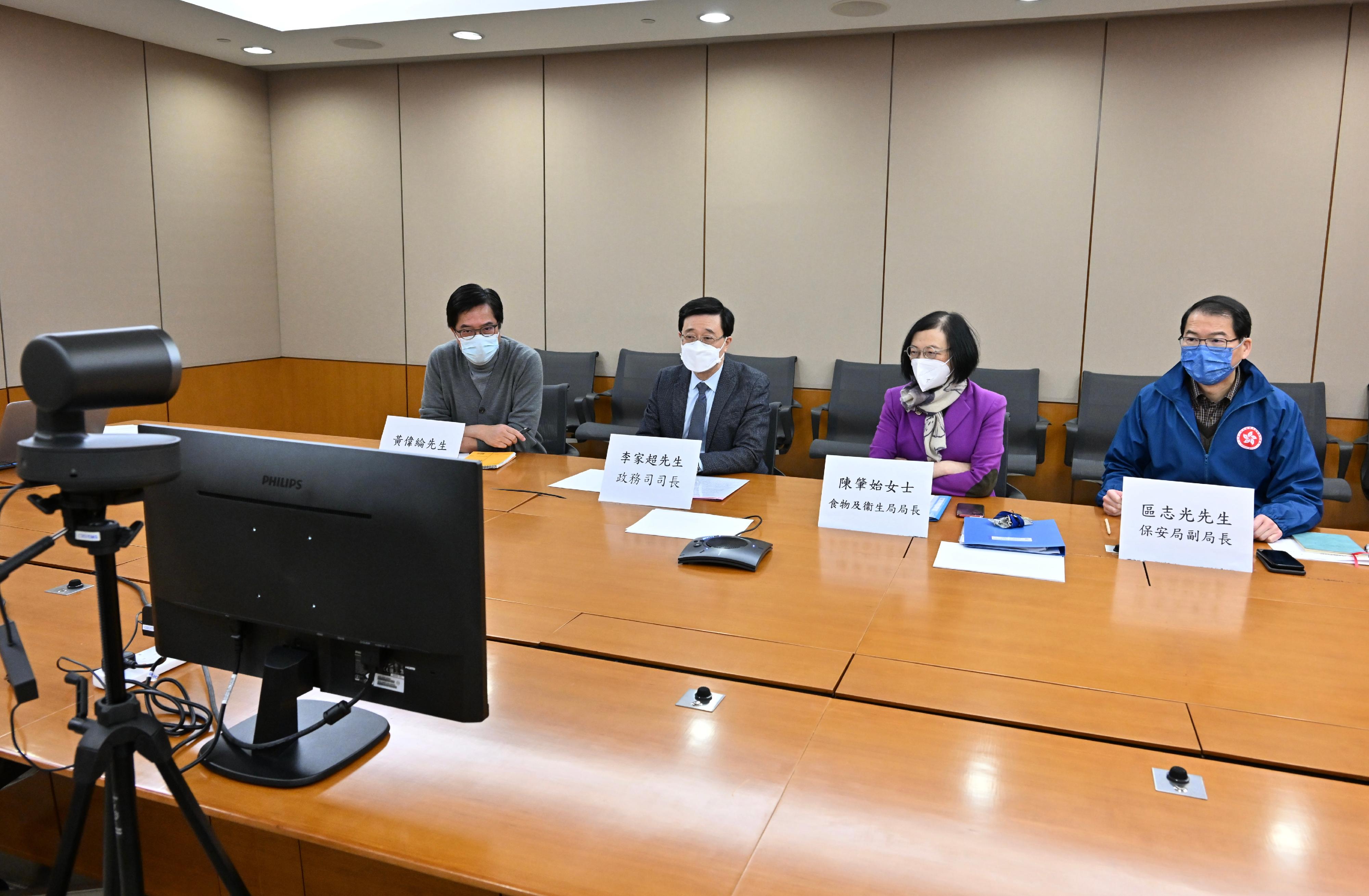 The Chief Secretary for Administration, Mr John Lee, held meetings today (February 28) on the commencement of the Tsing Yi community isolation facility. Photo shows Mr Lee (second left) holding a meeting with the Liaison Office of the Central People's Government in the Hong Kong Special Administrative Region and the contractor via video conferencing to follow up on the construction progress of the Tsing Yi community isolation facility. Looking on are the Secretary for Food and Health, Professor Sophia Chan (second right); the Secretary for Development, Mr Michael Wong (first left); and the Under Secretary for Security, Mr Sonny Au (first right).