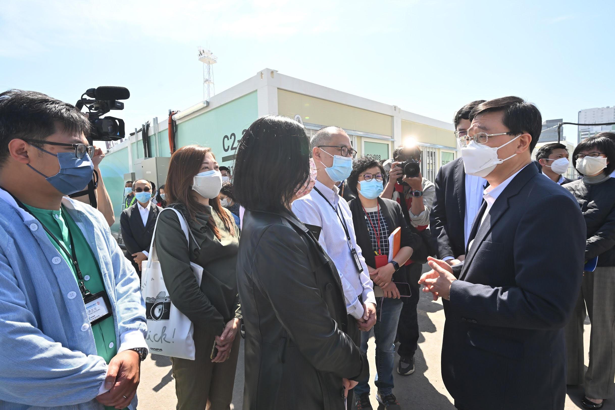 The Chief Secretary for Administration, Mr John Lee, today (March 1) visited the community isolation facilities constructed with the support of the Central Government in Tsing Yi. Photo shows Mr Lee (first right) having a conversation with medical and nursing staff of the Hospital Authority.