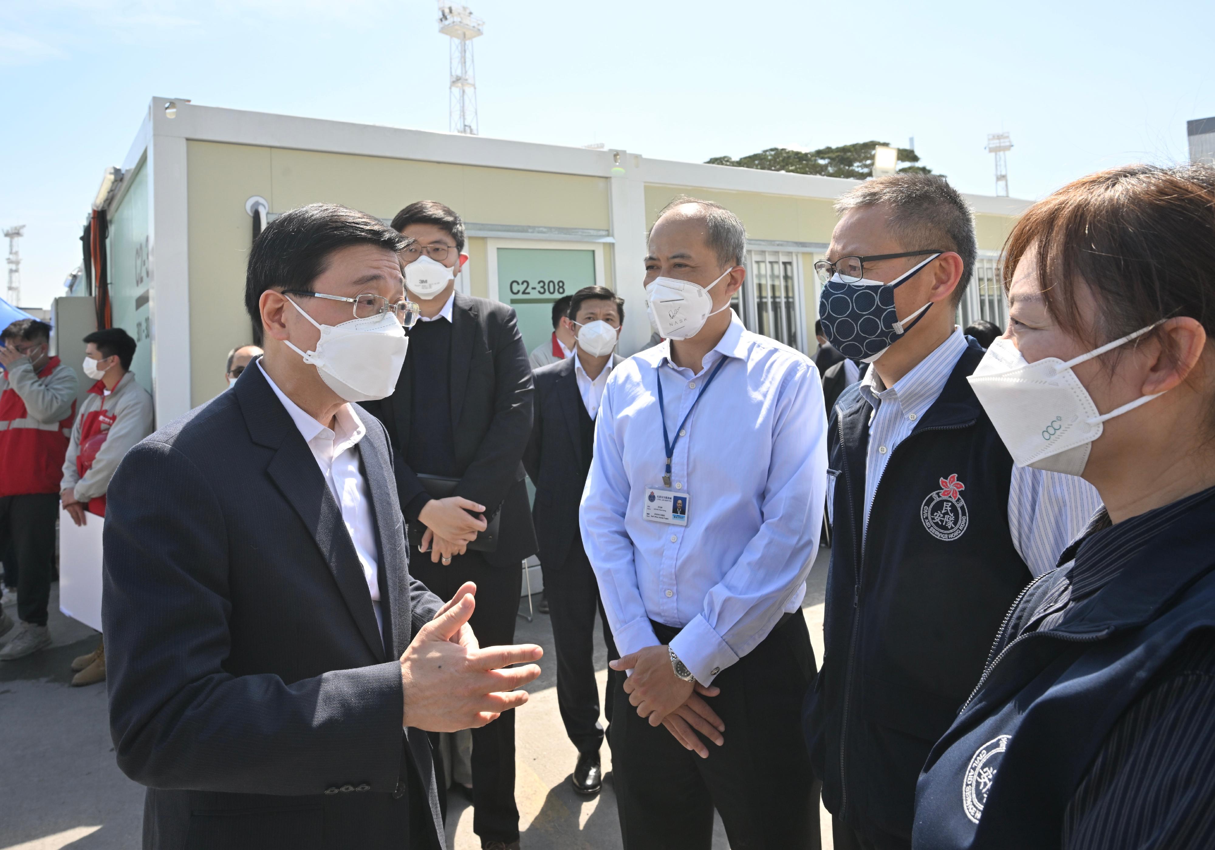 The Chief Secretary for Administration, Mr John Lee, today (March 1) visited the community isolation facilities constructed with the support of the Central Government in Tsing Yi. Photo shows Mr Lee (first left) having a conversation with Civil Aid Service's personnel on site and giving them words of encouragement.