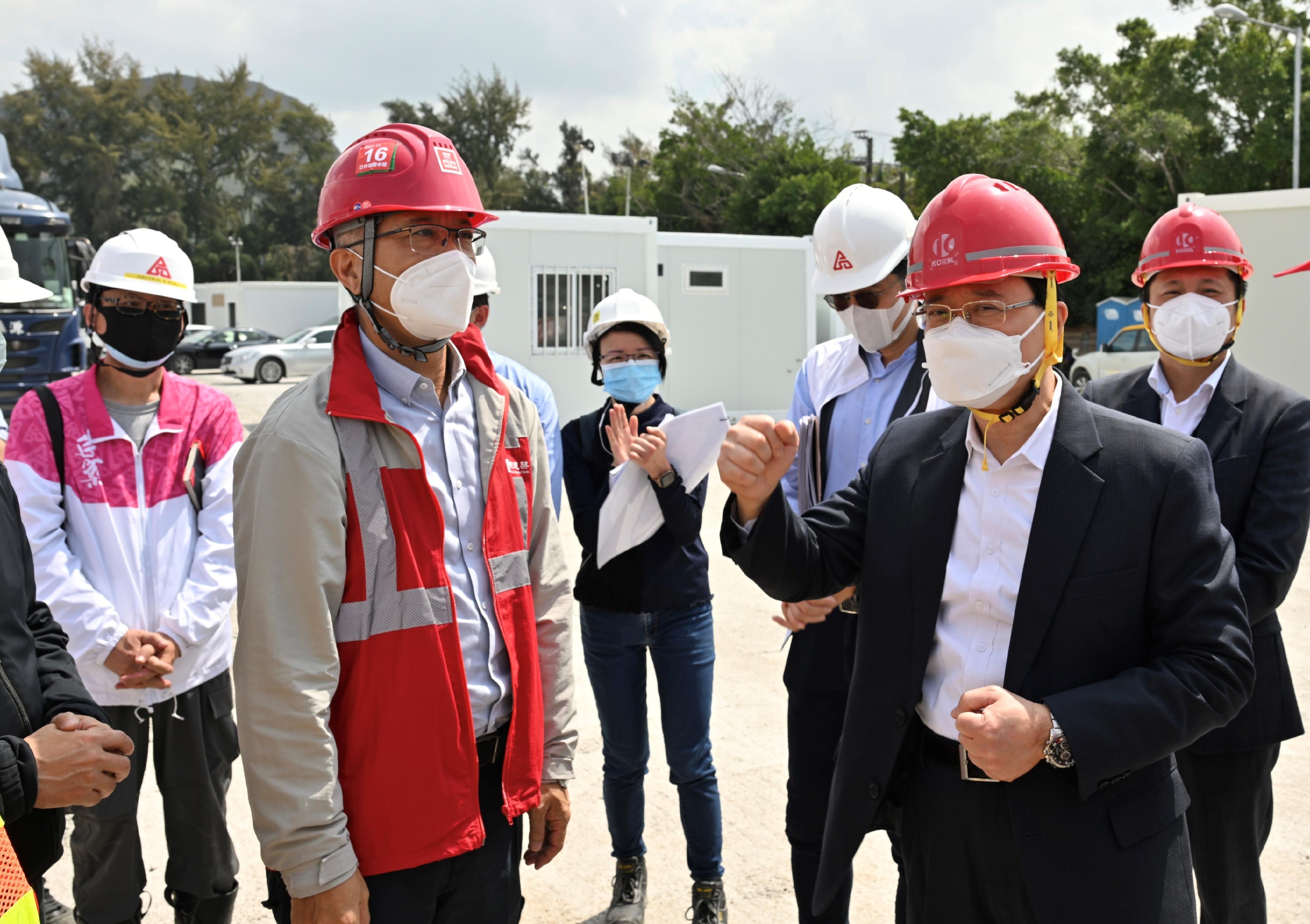The Chief Secretary for Administration, Mr John Lee, visited the community isolation and treatment facilities constructed with the support of the Central Government in Tsing Yi, Lok Ma Chau and San Tin today (March 1). Photo shows Mr Lee (front row, right) giving words of encouragement to works personnel at the site in San Tin.