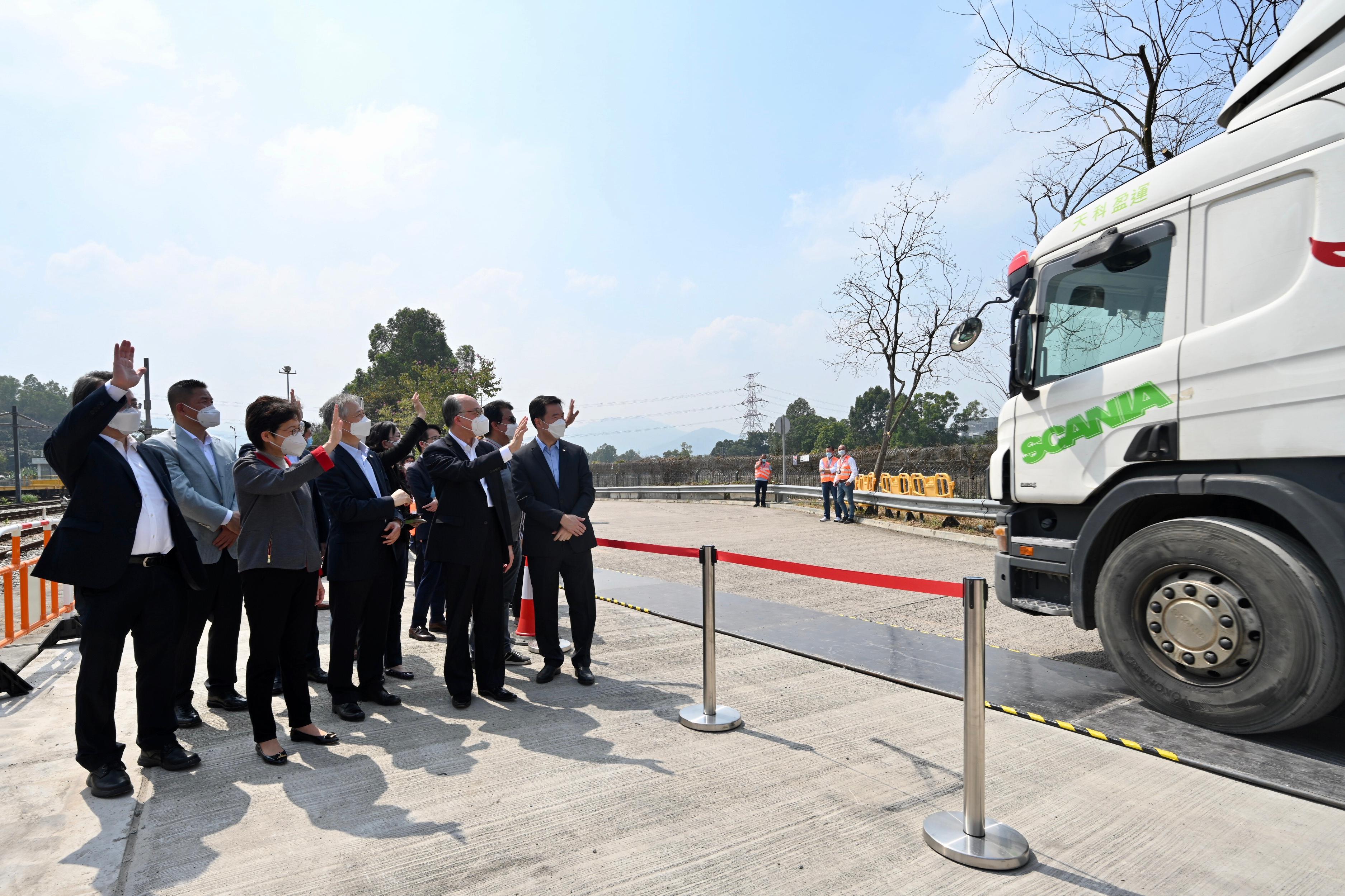 The railway transportation of goods from the Mainland to Hong Kong commenced today (March 2) with the first train carrying anti-epidemic supplies arriving at Hong Kong this morning. Photo shows the Chief Executive, Mrs Carrie Lam (first row, second left); the Secretary for Transport and Housing, Mr Frank Chan Fan (first row, second right); the Assistant President of the China Merchants Group Limited, Mr Chu Zongsheng (first row, centre); the Chief Executive Officer of MTR Corporation Limited, Dr Jacob Kam (first row, first left); and other personnel, waving to the goods vehicle driver. 