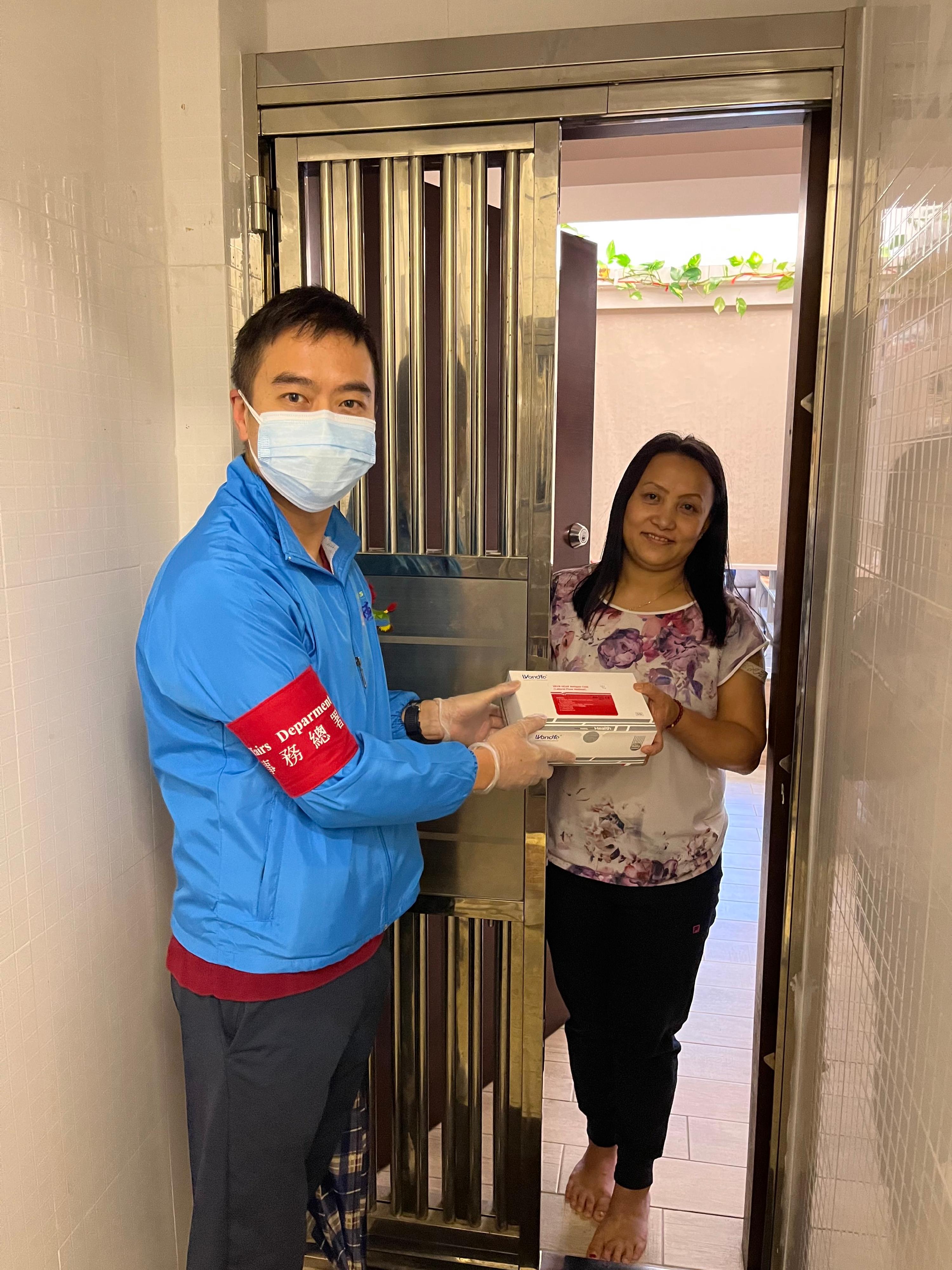 The Yau Tsim Mong District Office distributed rapid test kits supplied by the Central Government at residential buildings in the district on March 3. The beneficiaries included ethnic minority residents. Photo shows the District Officer (Yau Tsim Mong), Mr Edward Yu (left), distributing rapid test kits to an ethnic minority resident.
