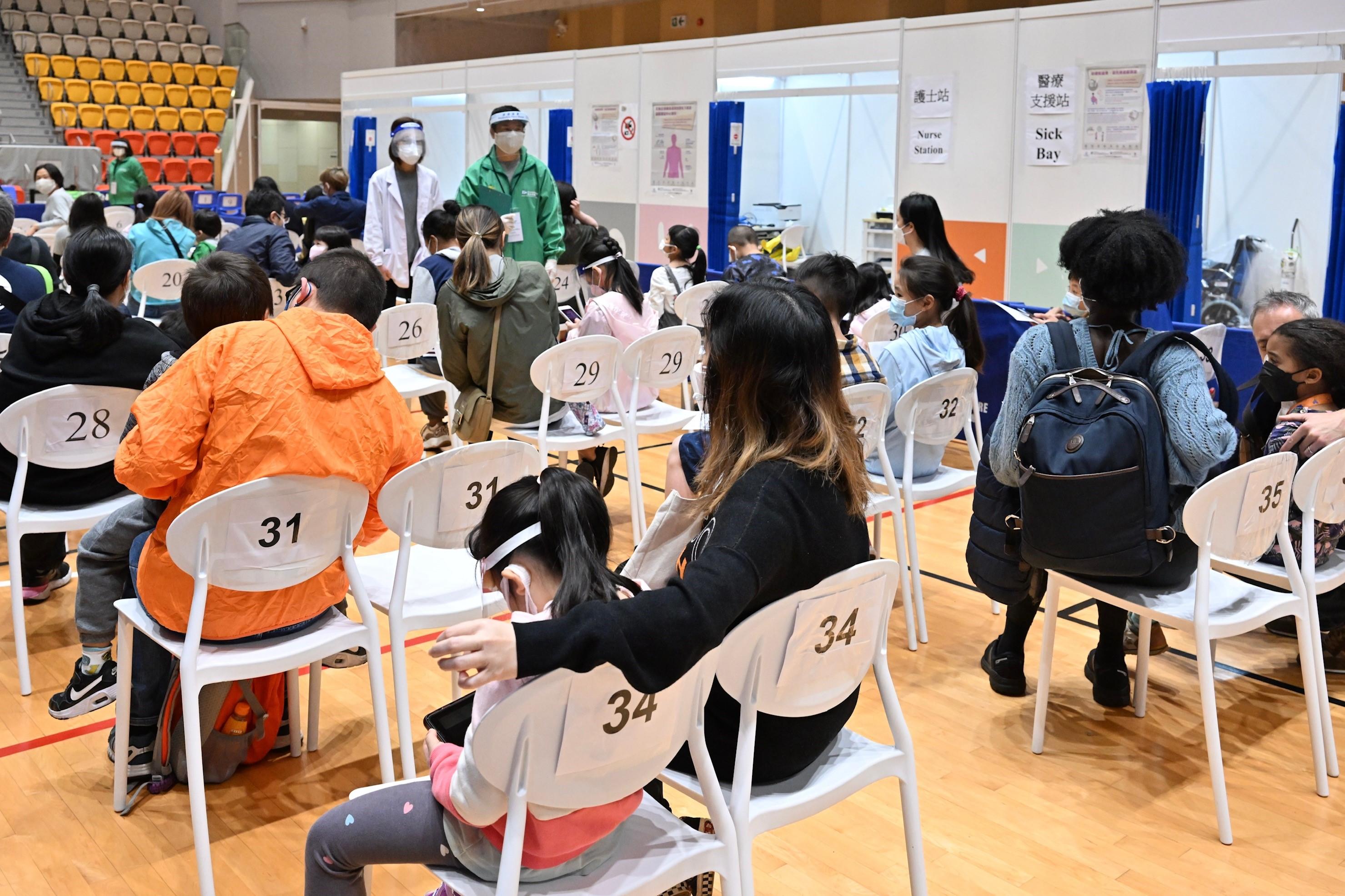 The Children Community Vaccination Centre at Tsuen Wan Sports Centre came into operation today (March 4) to provide the BioNTech vaccination service to children aged 5 to 11. Photo shows children and their parents/guardians at the waiting area for vaccination.