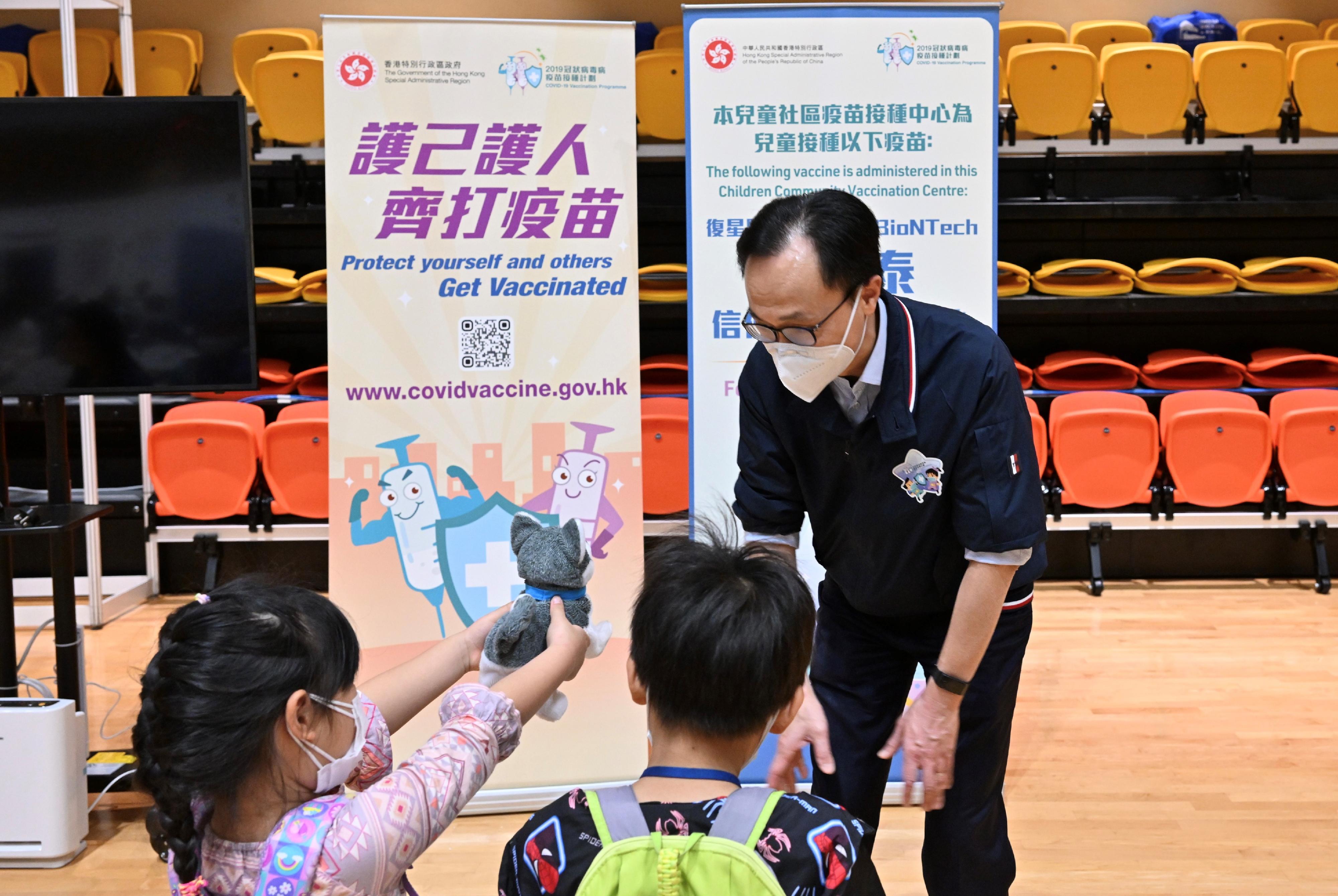 The Children Community Vaccination Centre at Tsuen Wan Sports Centre came into operation today (March 4) to provide the BioNTech vaccination service to children aged 5 to 11. Photo shows the Secretary for the Civil Service, Mr Patrick Nip (right), chatting with two children who are waiting for vaccination. 