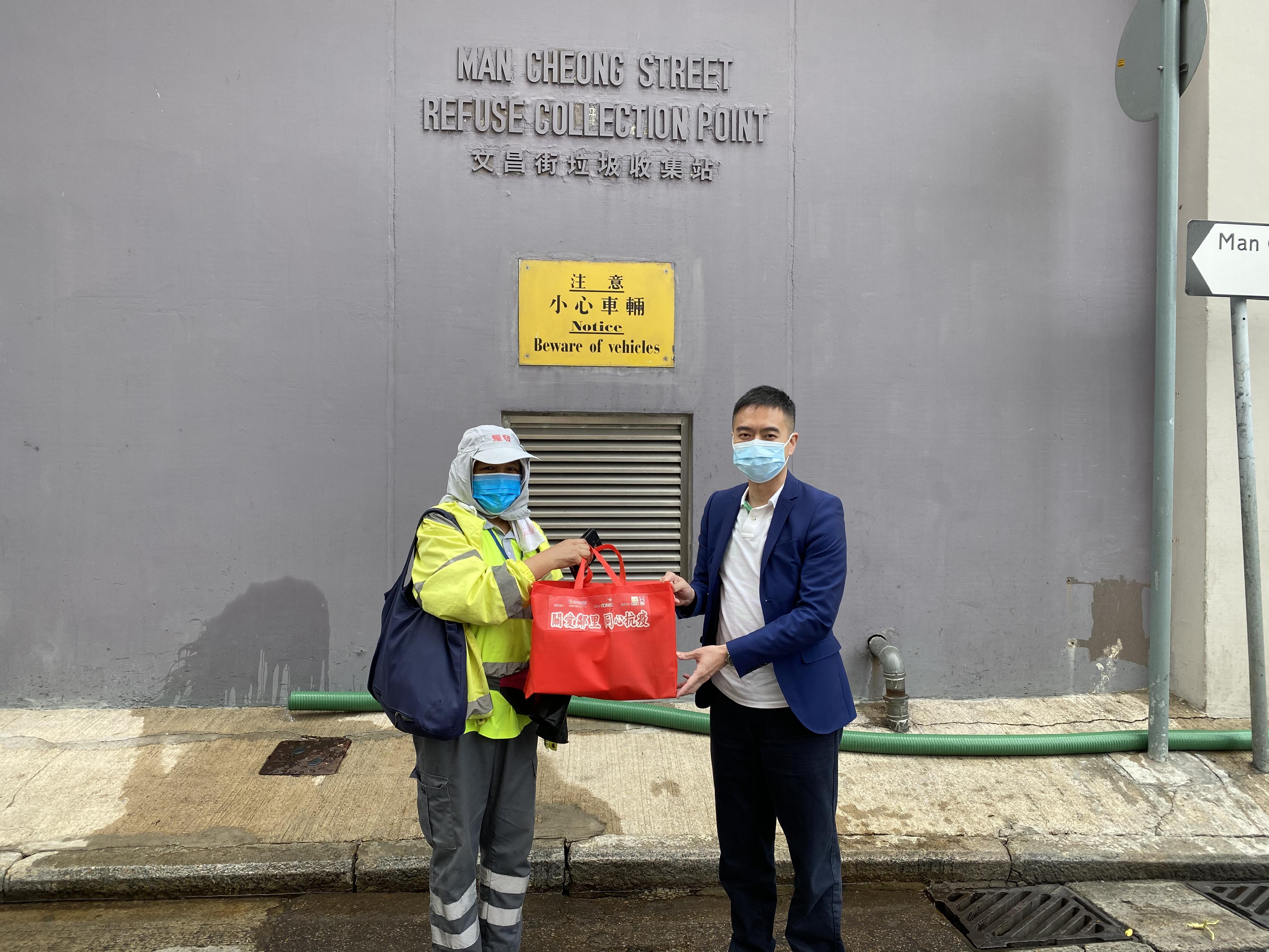 The Yau Tsim Mong District Office and local organisations distributed anti-epidemic supplies to frontline workers of Yau Tsim Mong District on March 6. Photo shows the District Officer (Yau Tsim Mong), Mr Edward Yu (right), distributing the supplies to ethnic minority cleaning workers at Man Cheong Street Refuse Collection Point.