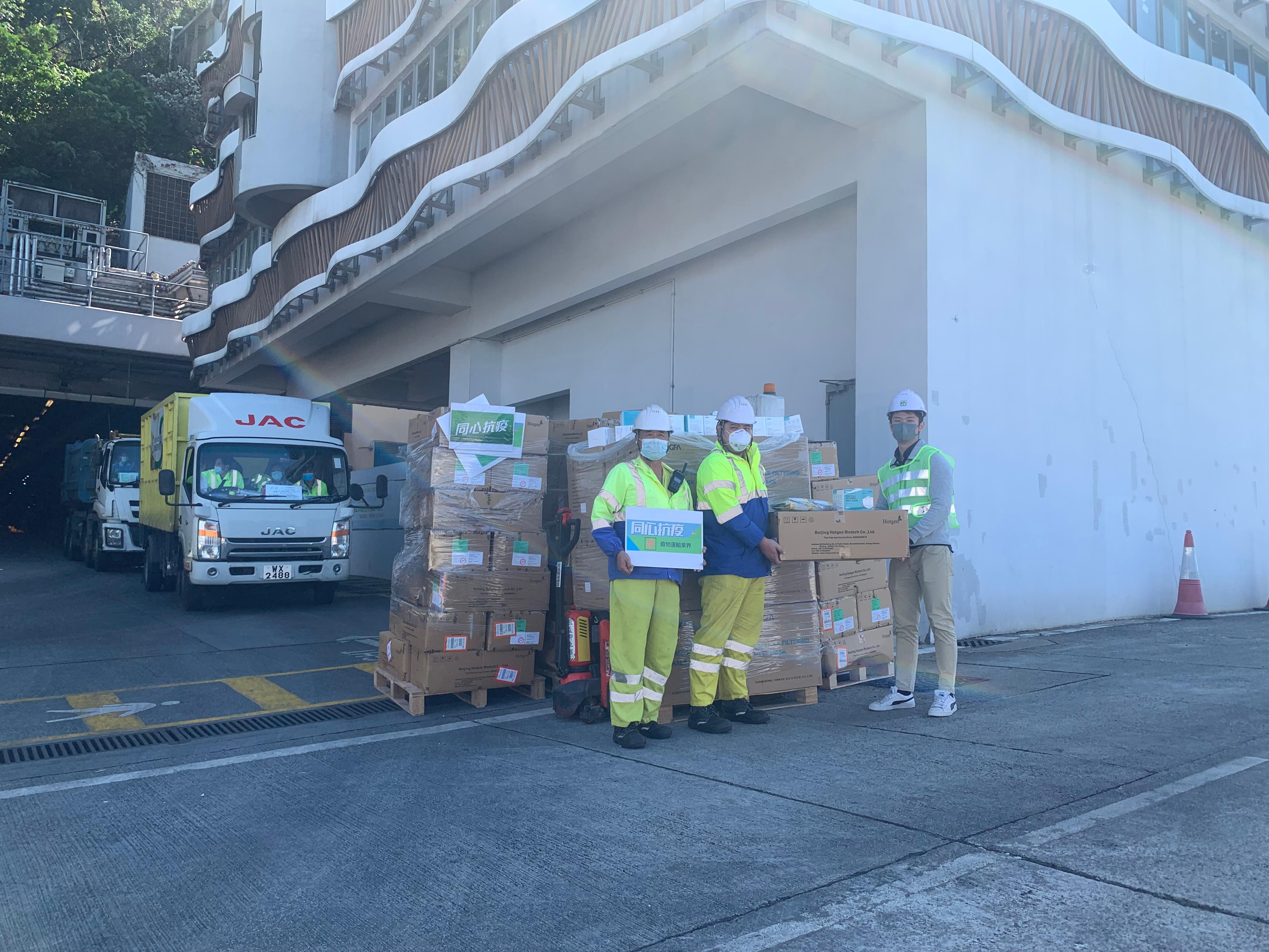 The Environmental Protection Department (EPD) has distributed KN95 masks and rapid antigen test (RAT) kits to contractor staff of landfills and refuse transfer stations to assist them in fighting against the epidemic. Picture shows an EPD staff member distributing masks and RAT kits to the representatives of refuse transfer station contractors.