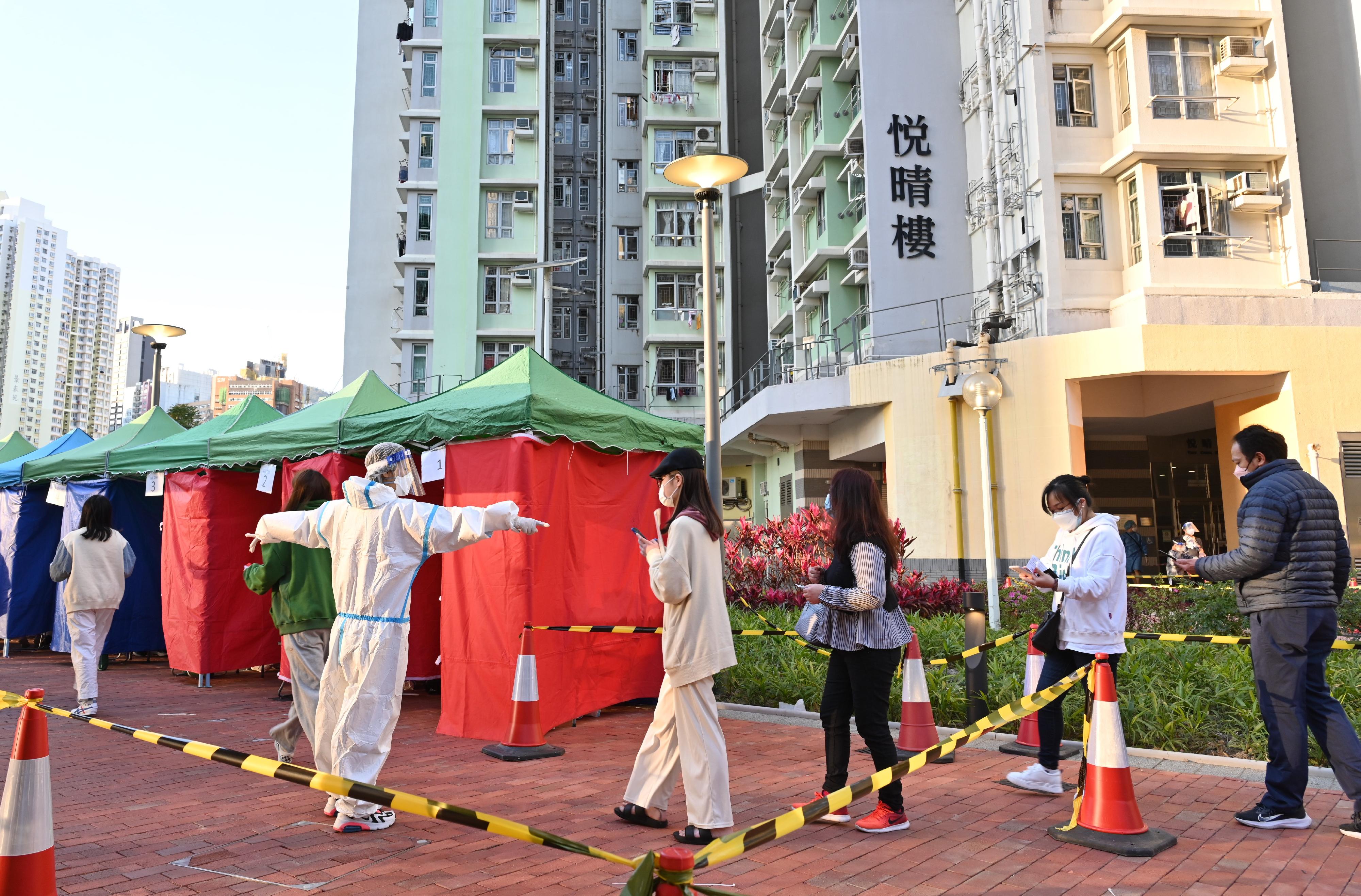 The Trade and Industry Department (TID) yesterday (March 7) conducted a "restriction-testing declaration" operation in the "restricted area" at Yuet Ching House, Kai Ching Estate, Kowloon City. Photo shows TID staff arranging for persons subject to compulsory testing to undergo testing.