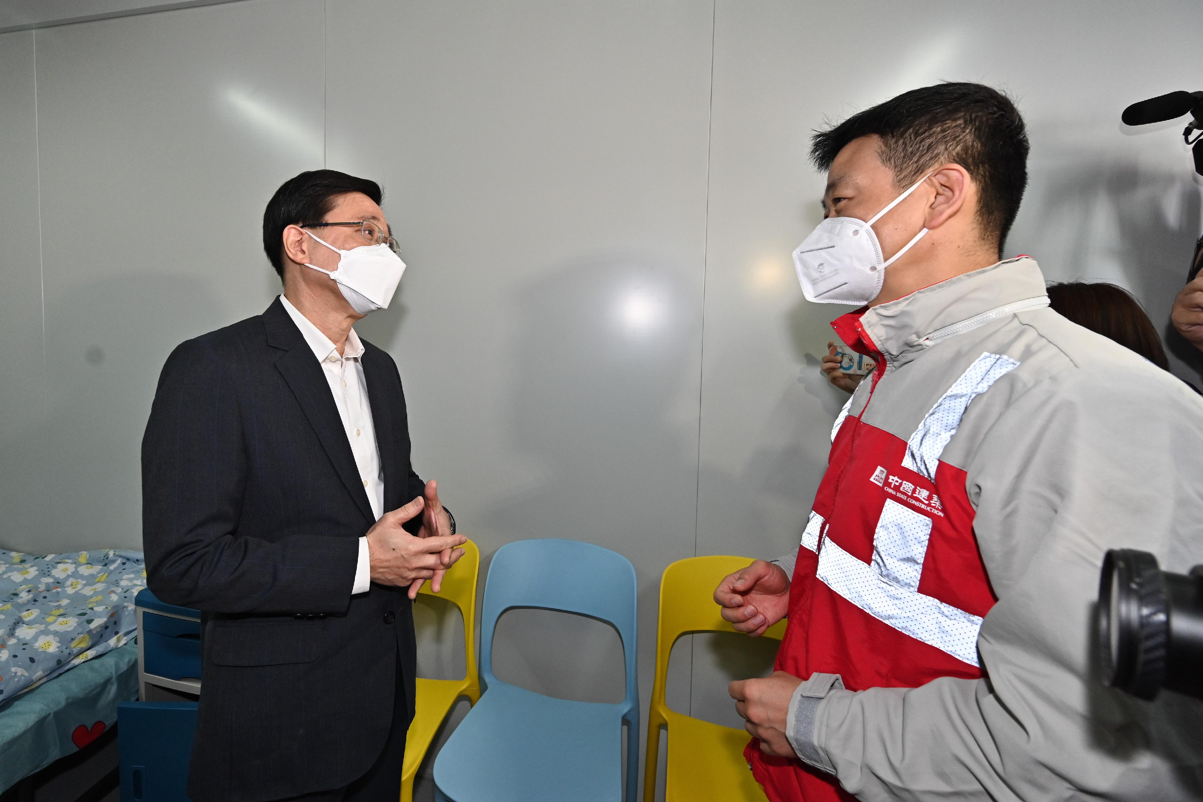 The Chief Secretary for Administration, Mr John Lee, today (March 9) visited the community isolation facility constructed with the support of the Central Government in San Tin. Photo shows Mr Lee (left) receiving a briefing from a staff member of the contractor on a newly constructed unit.