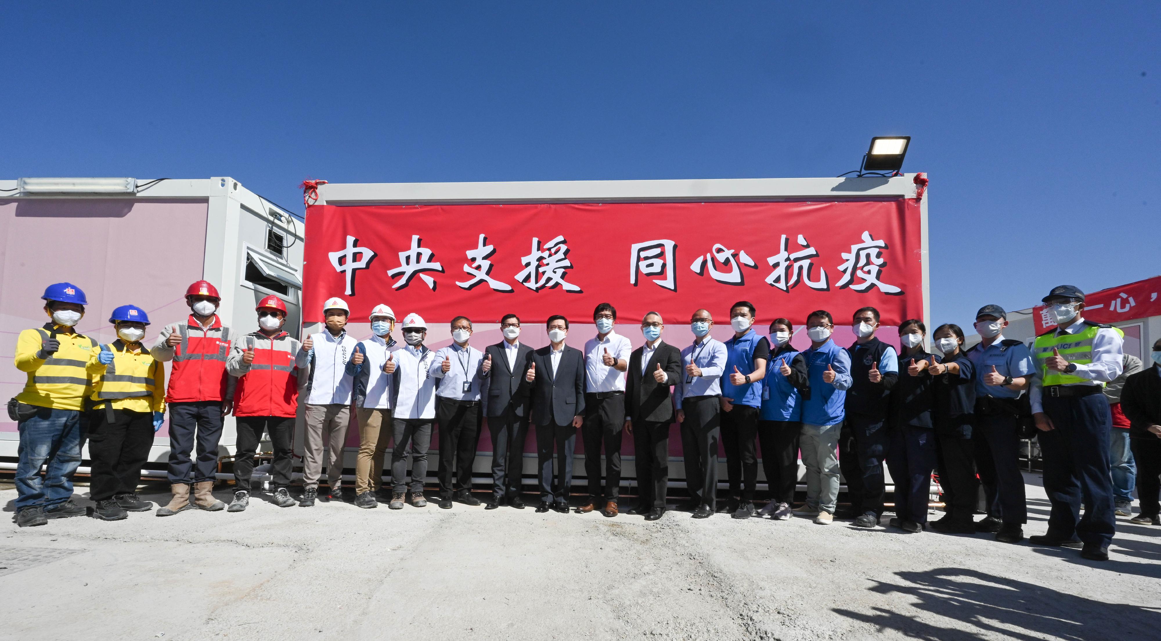 The Chief Secretary for Administration, Mr John Lee, today (March 9) visited the community isolation facility constructed with the support of the Central Government in San Tin. Photo shows Mr Lee (tenth left); the Secretary for Development, Mr Michael Wong (eleventh left); the Secretary for Security, Mr Tang Ping-keung (ninth left); the Under Secretary for Food and Health, Dr Chui Tak-yi (tenth right), and the staff on-site.