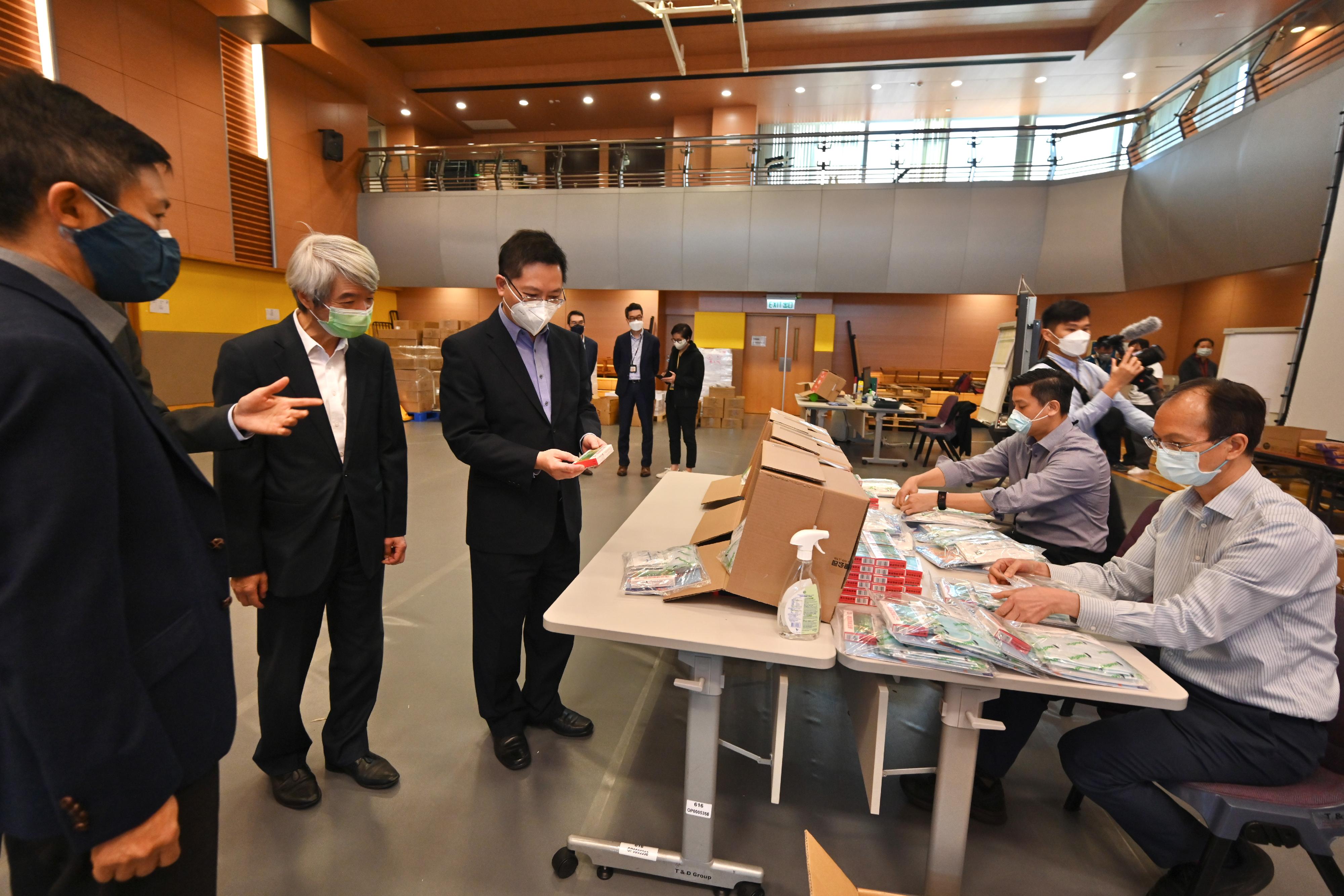 The Secretary for Innovation and Technology, Mr Alfred Sit (third left), inspects the anti-epidemic kit distribution centre located in the Independent Commission Against Corruption (ICAC) today (March 10) and takes a closer look at the anti-epidemic proprietary Chinese medicine "Lianhua Qingwen Jiaonang" to be distributed to confirmed patients. Looking on is the ICAC Commissioner, Mr Simon Peh (first left).