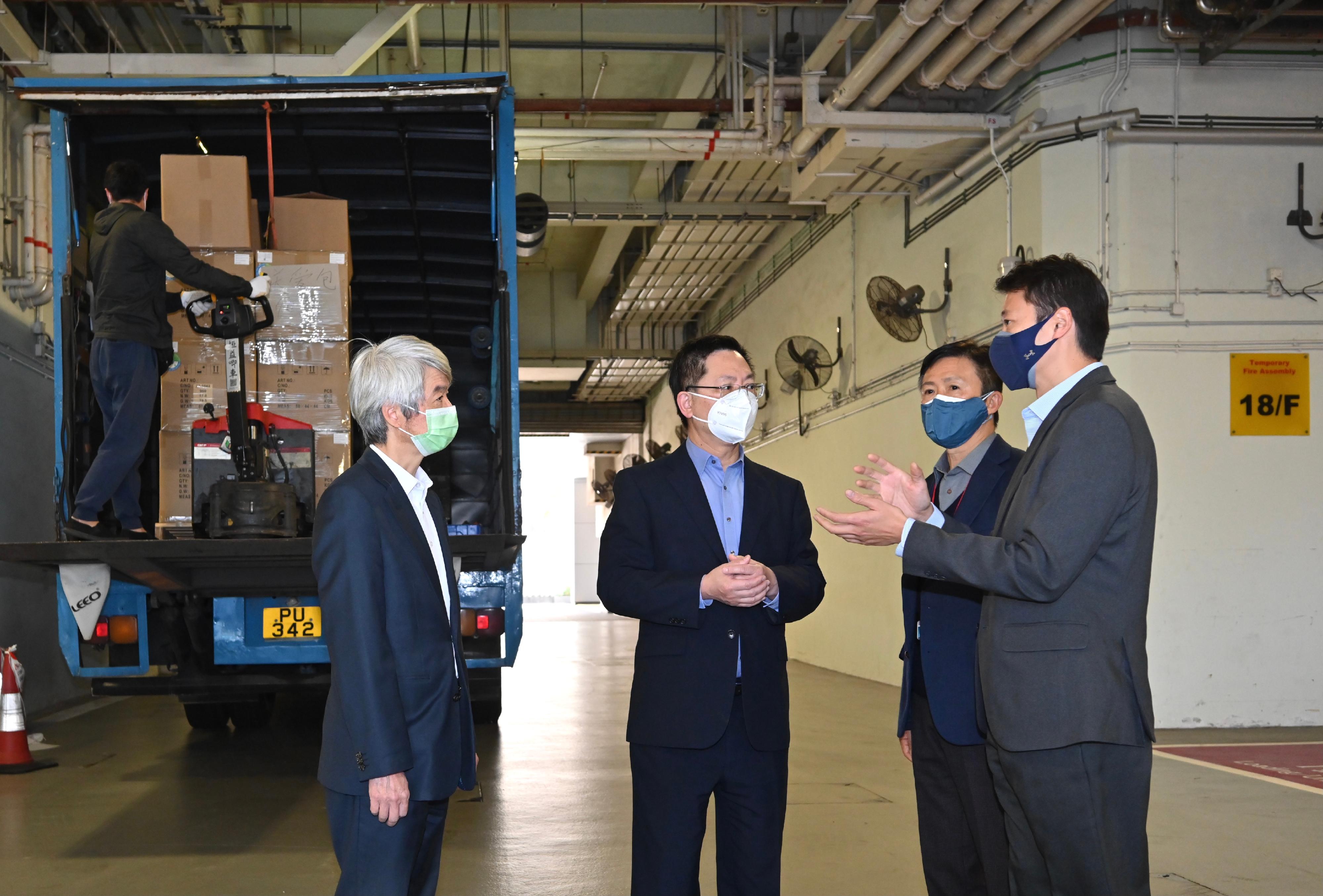 The Secretary for Innovation and Technology, Mr Alfred Sit (second left), inspects the anti-epidemic kit distribution centre located in the Independent Commission Against Corruption (ICAC) and receives a briefing on the logistical arrangements of the kits today (March 10). Looking on is the ICAC Commissioner, Mr Simon Peh (second right).