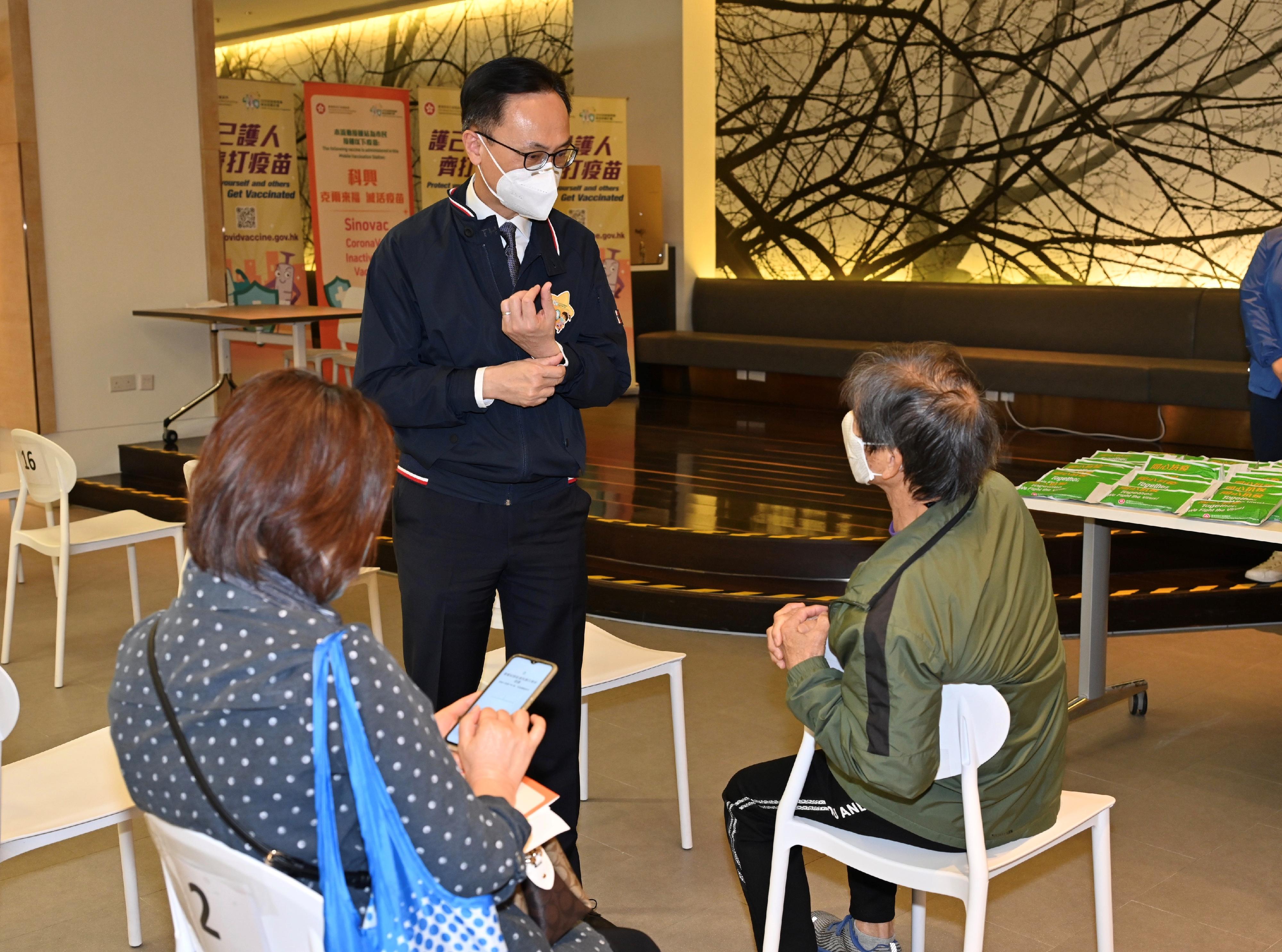 The Secretary for the Civil Service, Mr Patrick Nip, and the Group Deputy Chairman of the Fung Group, Dr William Fung, today (March 11) jointly inspected the operation of the Hong Kong Spinners Industrial Building Community Vaccination Centre. Photo shows Mr Nip (centre) chatting with a member of the public who had just received vaccination.