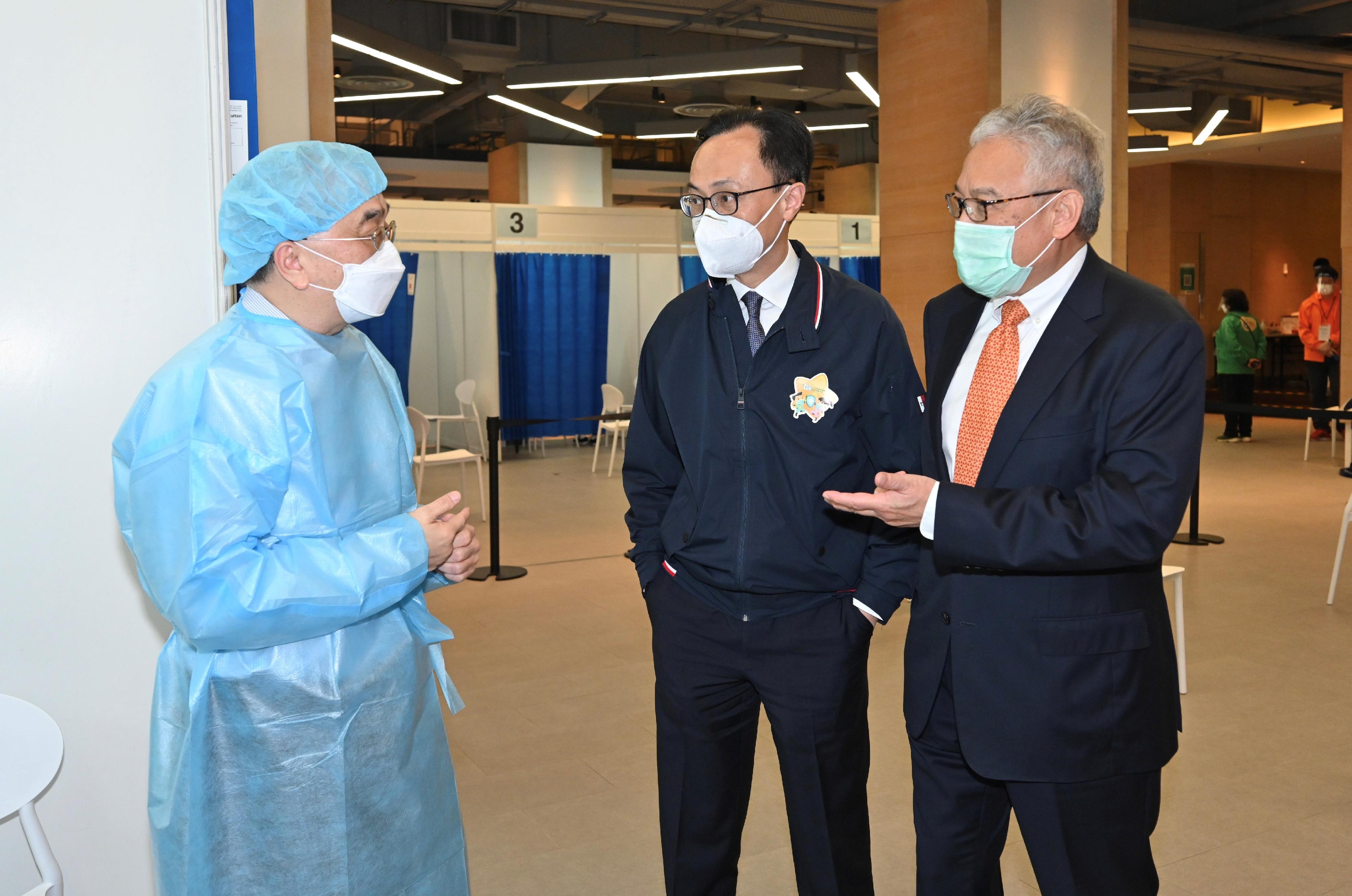The Secretary for the Civil Service, Mr Patrick Nip, and the Group Deputy Chairman of the Fung Group, Dr William Fung, today (March 11) jointly inspected the operation of the Hong Kong Spinners Industrial Building Community Vaccination Centre (CVC). Photo shows Mr Nip (centre) and Dr Fung (right) chatting with a medical staff member of the CVC.