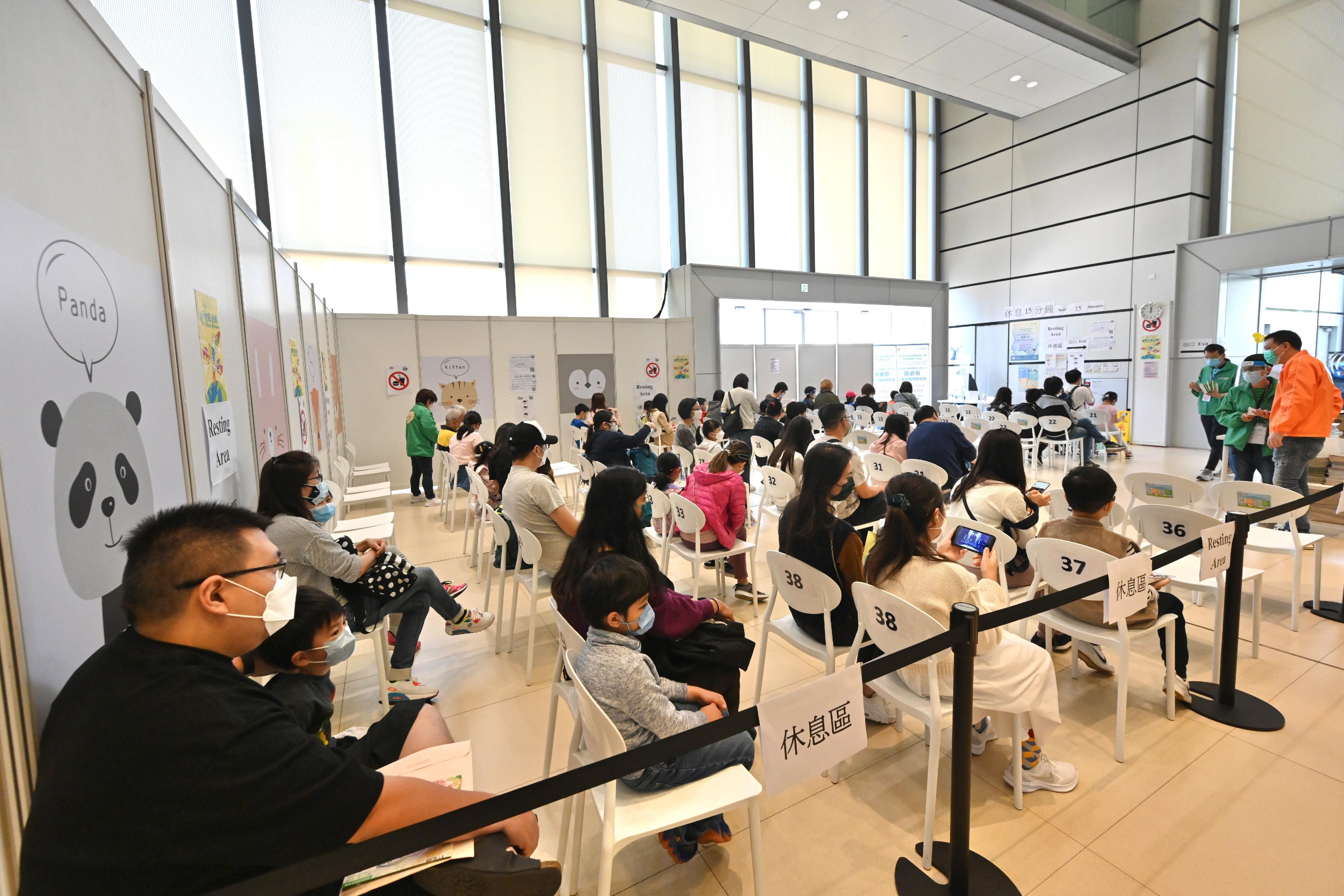 The Hong Kong Children's Hospital Children Community Vaccination Centre in Kowloon Bay is dedicated to providing the BioNTech vaccination service to children aged 5 to 11. Photo shows vaccinated children and their parents in the resting area.