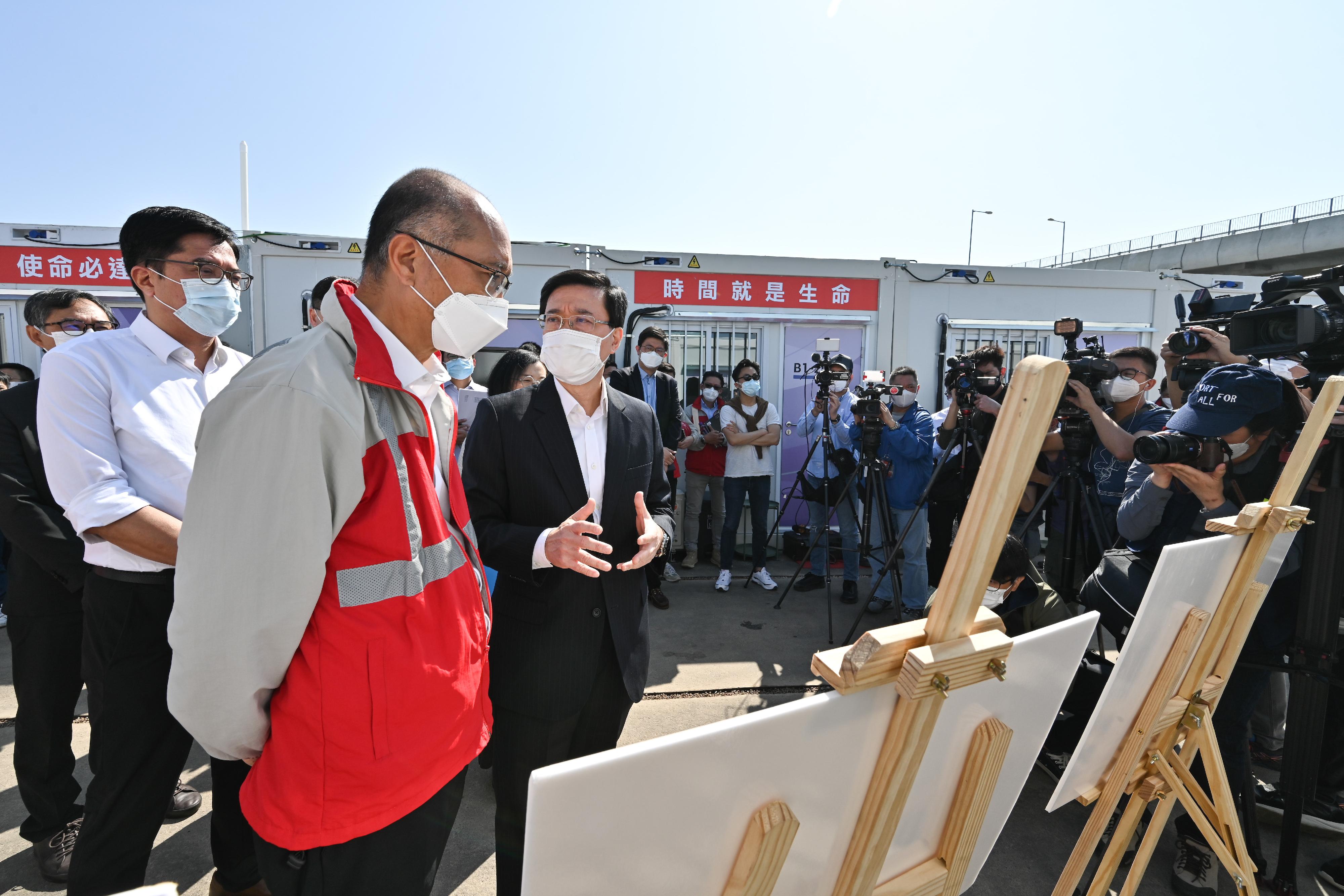The Chief Secretary for Administration, Mr John Lee, this morning (March 12) visited the third community isolation facility constructed with Mainland support on the Hong Kong Boundary Crossing Facilities Island of the Hong Kong-Zhuhai-Macao Bridge. Photo shows Mr Lee (first right) receiving a briefing from a representative of the contractor on the facility.