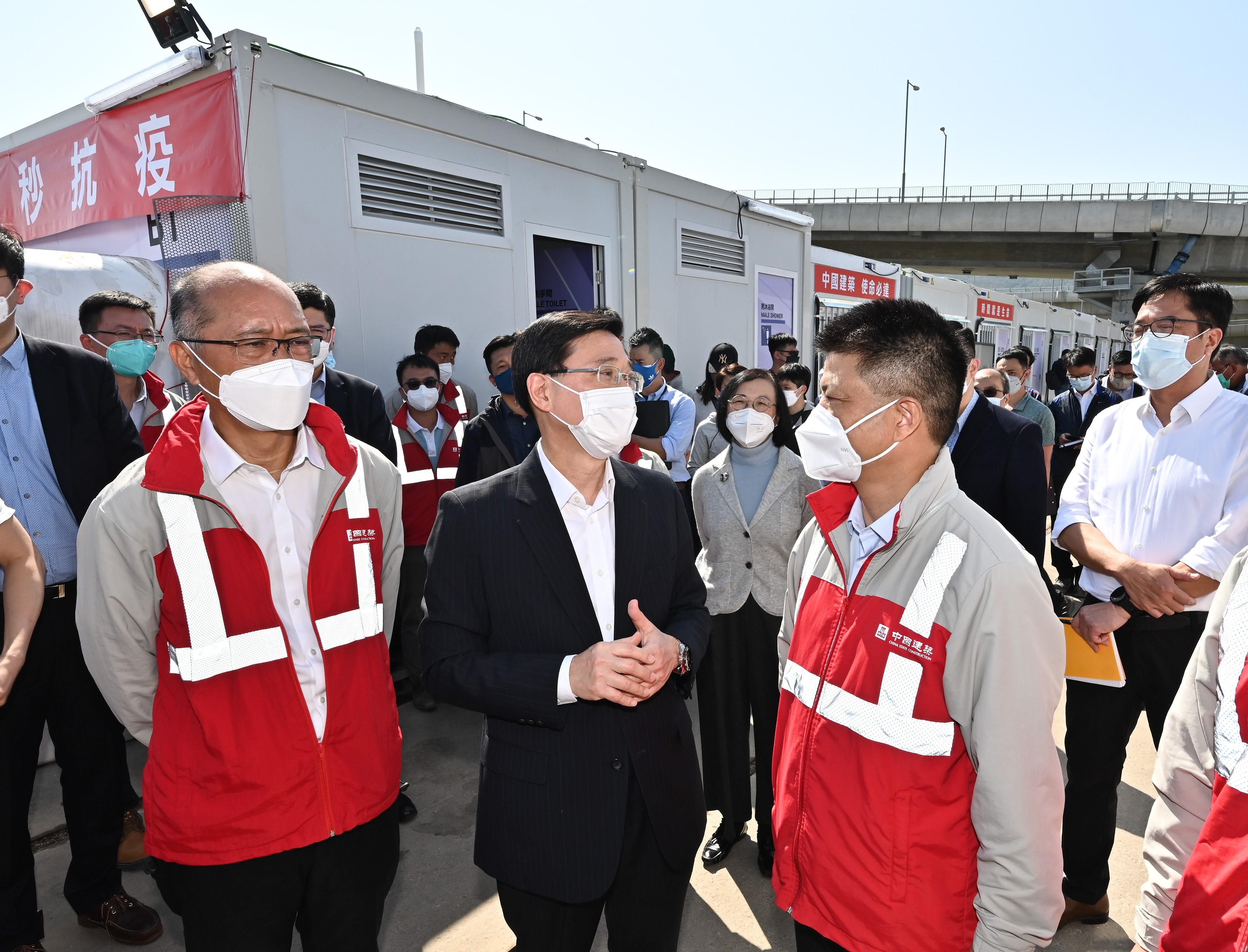 The Chief Secretary for Administration, Mr John Lee, this morning (March 12) visited the third community isolation facility constructed with Mainland support on the Hong Kong Boundary Crossing Facilities Island of the Hong Kong-Zhuhai-Macao Bridge. Photo shows Mr Lee (second left) chatting with the Chairman and Non-executive Director of China State Construction International Holdings Limited, Mr Yan Jianguo (second right).