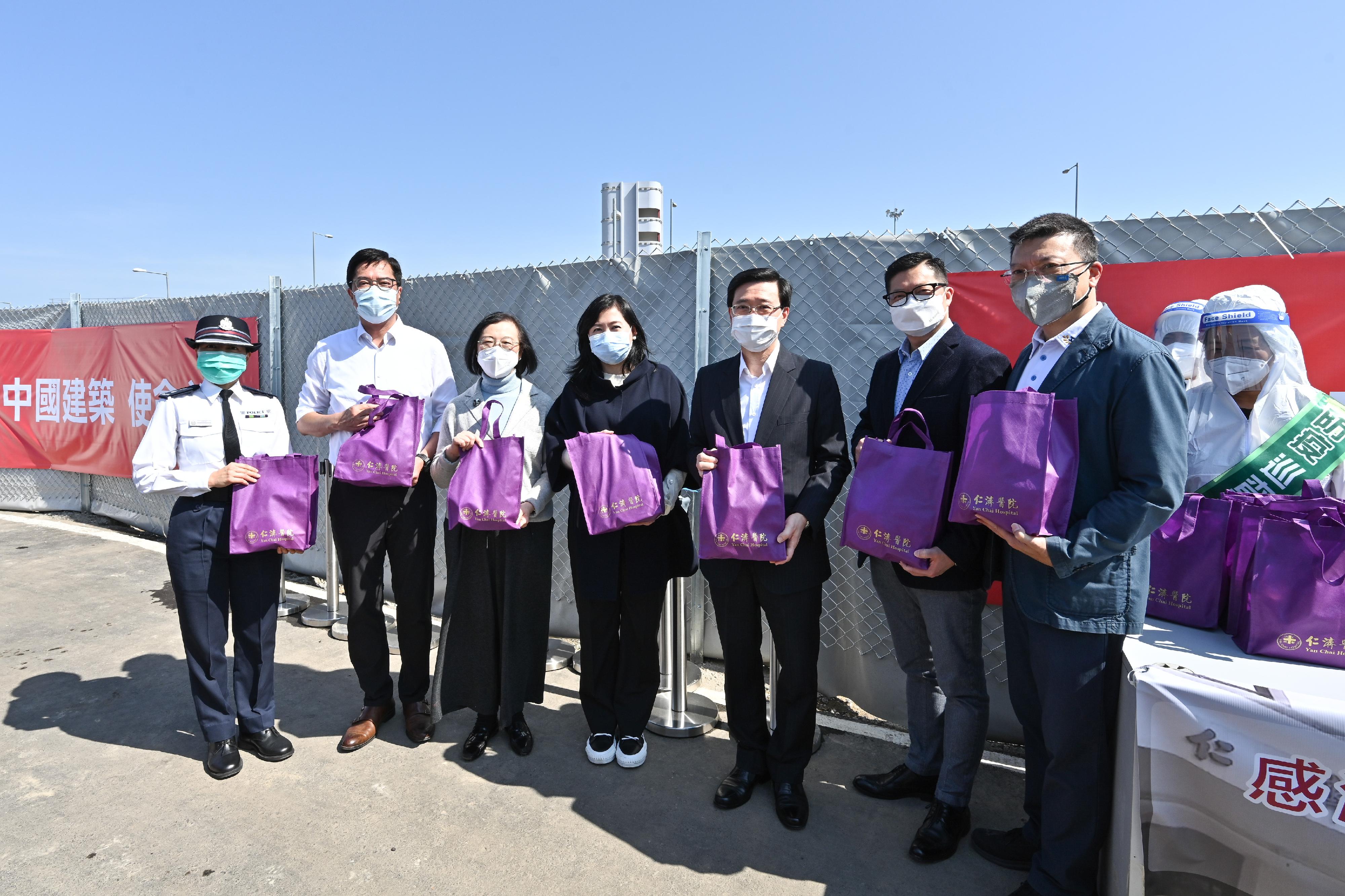 The Chief Secretary for Administration, Mr John Lee, this morning (March 12) visited the third community isolation facility constructed with Mainland support on the Hong Kong Boundary Crossing Facilities Island of the Hong Kong-Zhuhai-Macao Bridge. Photo shows Mr Lee (third right); the Chairman of the Board of Directors of Yan Chai Hospital, Ms Macy Wong (fourth right); the Secretary for Food and Health, Professor Sophia Chan (third left); the Secretary for Development, Mr Michael Wong (second left); and the Secretary for Security, Mr Tang Ping-keung (second right), holding anti-epidemic supplies kits donated by the Board of Directors of Yan Chai Hospital.