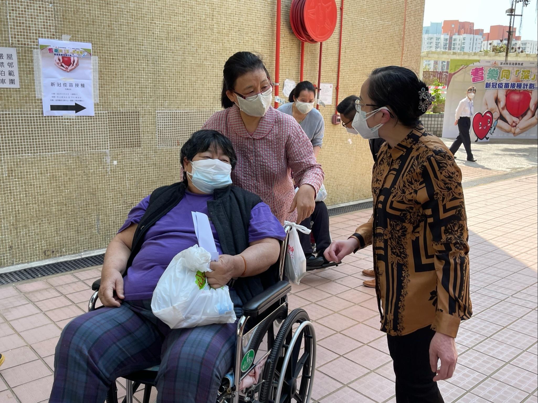The Acting Director of Home Affairs, Miss Vega Wong, officiated at the launch ceremony of a community vaccination programme for the elderly named "Vaccination for the Elderly in SSP" organised by the Sham Shui Po District Office held in Chak On Estate today (March 13). Photo shows Miss Wong (right) chatting with residents at the Estate to learn more about the difficulties they encounter and the support they need under the epidemic.
