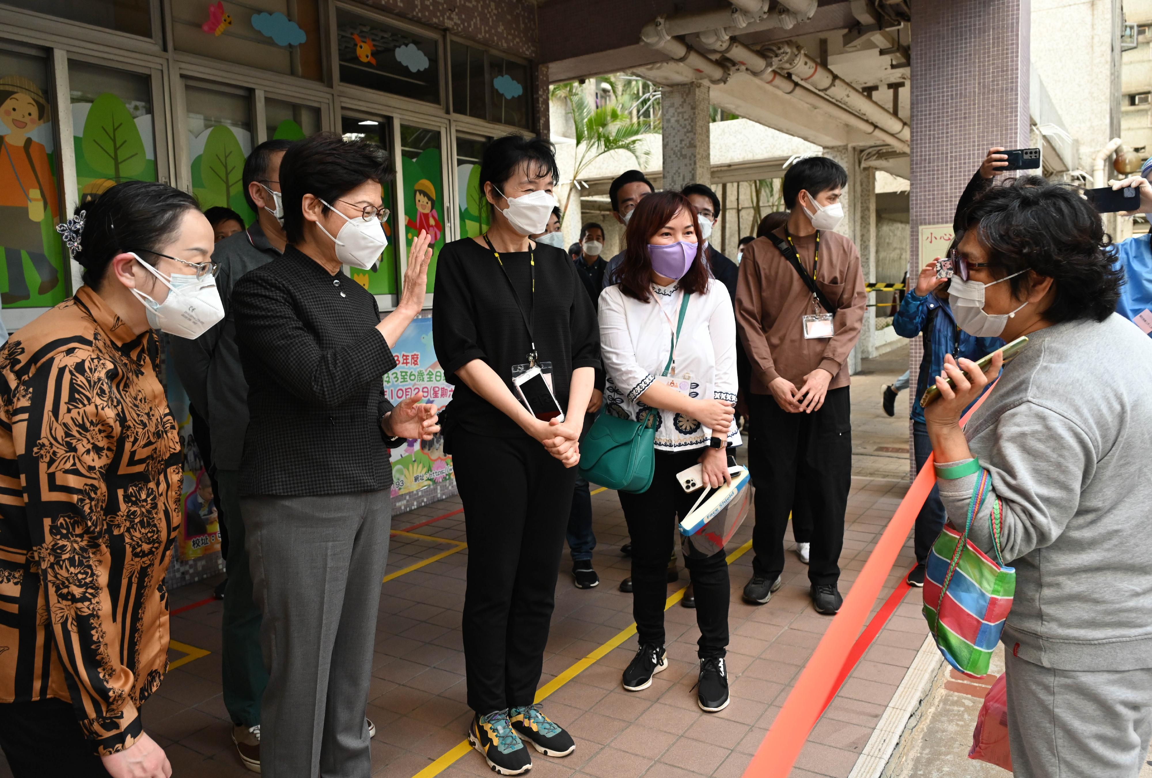 The Chief Executive, Mrs Carrie Lam, today (March 13) inspected the "restriction-testing declaration" operation at Tsui Ning Garden, Tuen Mun. Picture shows Mrs Lam (second left) chatting with a resident.