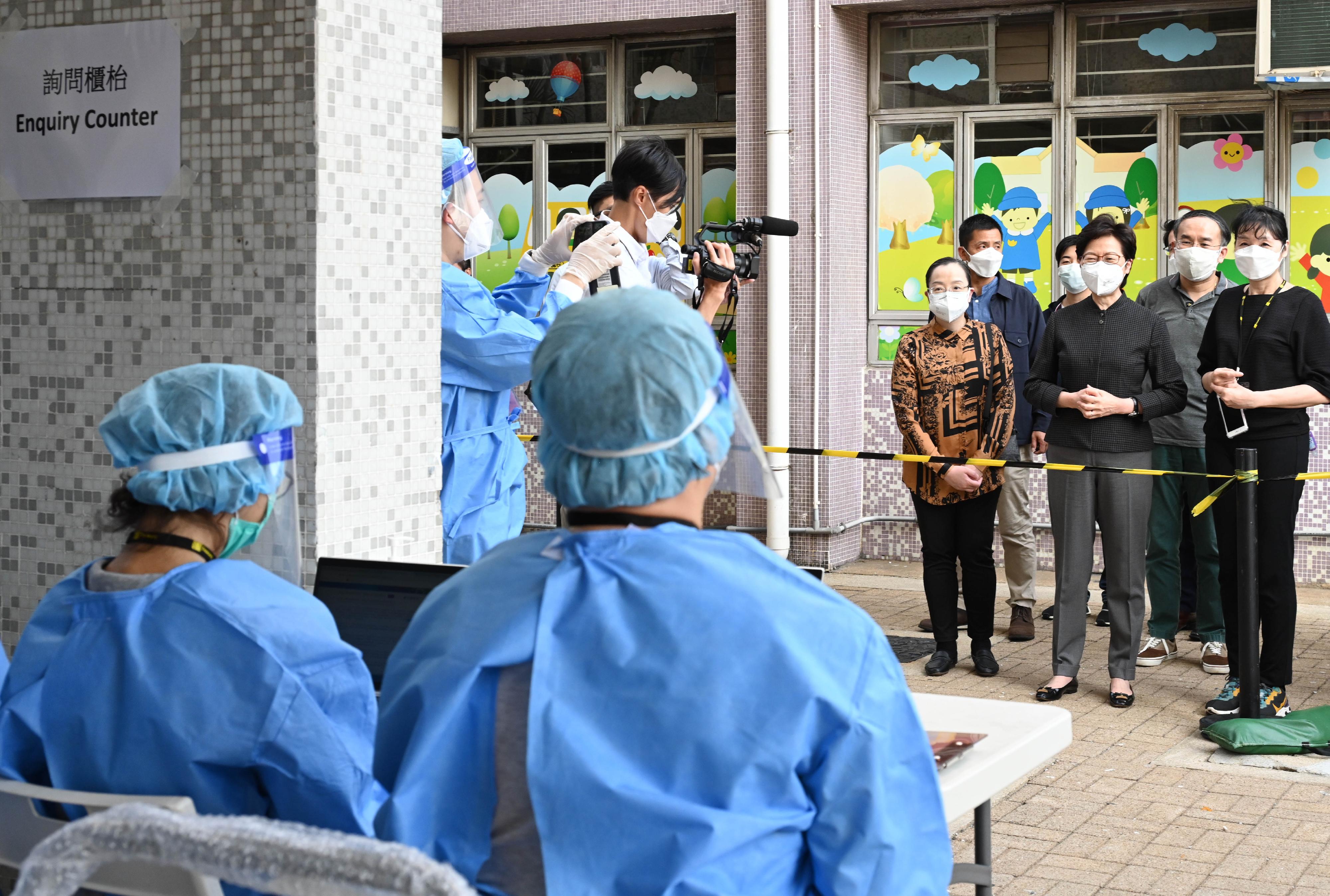 The Chief Executive, Mrs Carrie Lam, today (March 13) inspected the "restriction-testing declaration" operation at Tsui Ning Garden, Tuen Mun. Picture shows Mrs Lam (third right) giving encouragement to participating colleagues. Joining Mrs Lam is the Secretary for Financial Services and the Treasury, Mr Christopher Hui (second right).