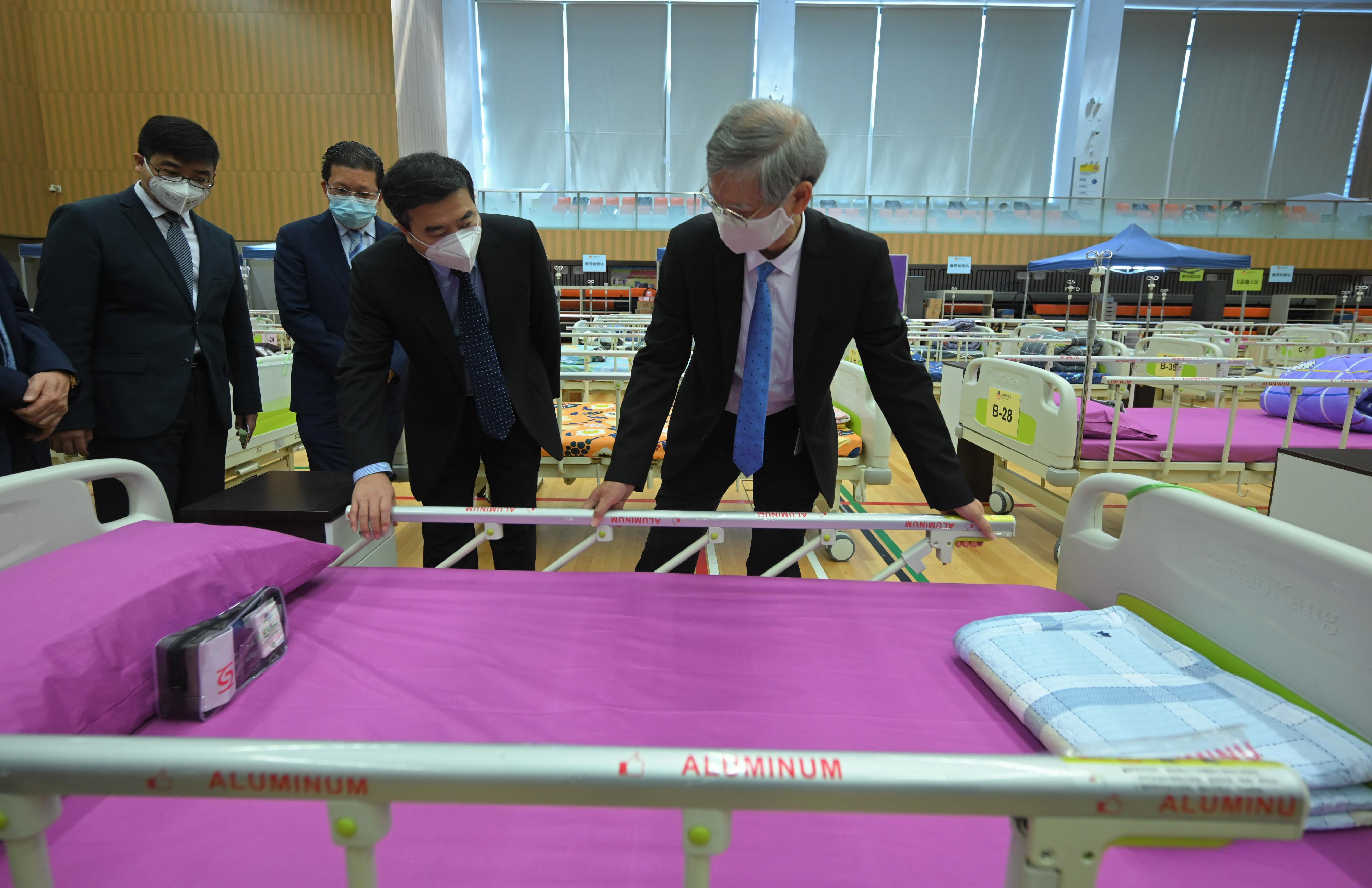 The Secretary for Labour and Welfare, Dr Law Chi-kwong, today (March 14) conveyed his appreciation to China Resources Charity Foundation for its donation of 1 000 hospital beds to the Social Welfare Department and assistance to the Government to set up isolation and holding centres in various sports centres. Photo shows Dr Law (first right) and the Assistant General Manager of China Resources Group and Chairman of the Board and Chief Executive Officer of China Resources Enterprise, Mr Chen Ying (second right), taking a closer look at the installation of hospital beds in Harbour Road Sports Centre in Wan Chai and how they facilitate elderly care.