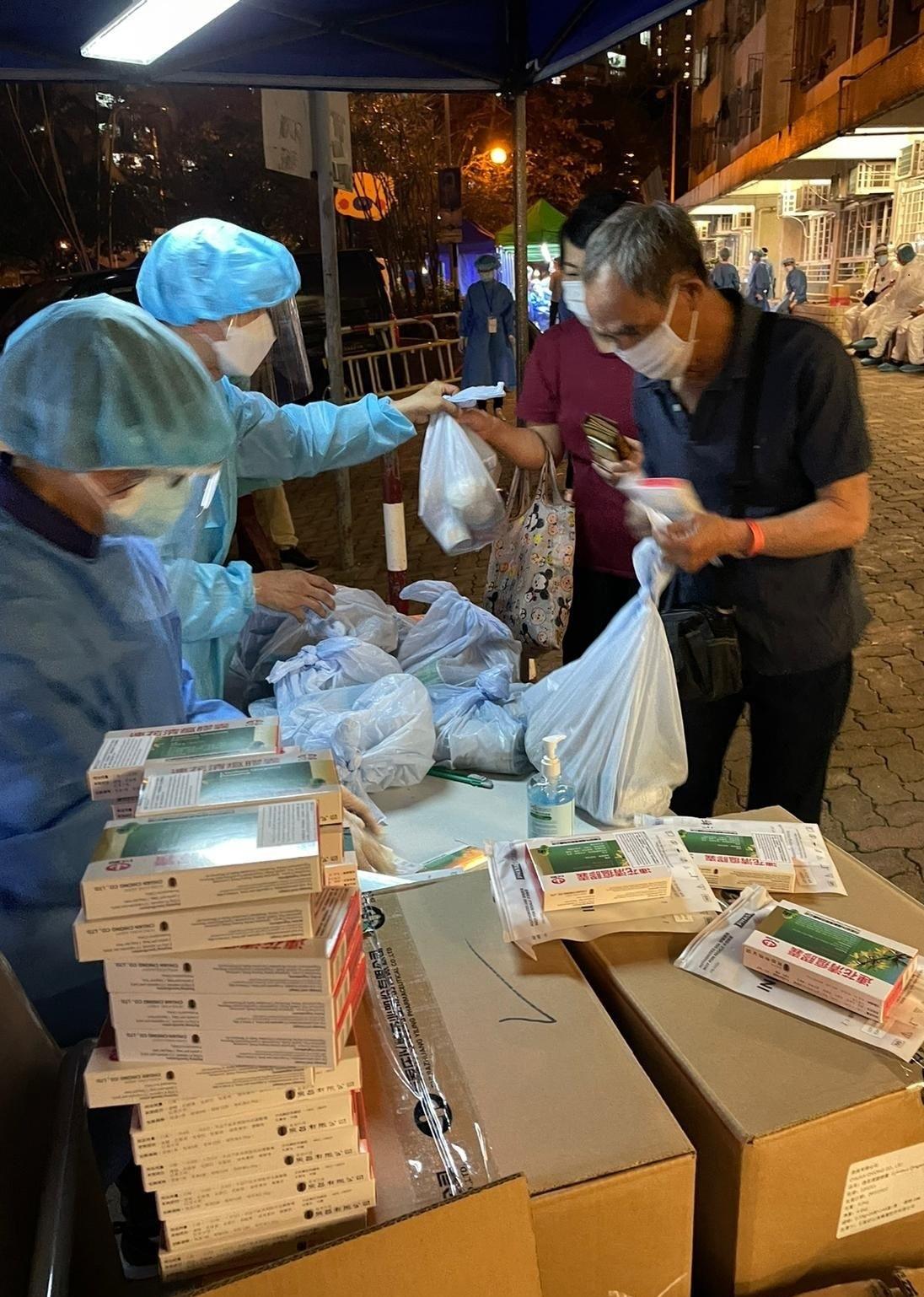 The Government yesterday (March 16) made a "restriction-testing declaration" and issued a compulsory testing notice in respect of the specified "restricted area" in Tip Yee House, Butterfly Estate, Tuen Mun. Photo shows staff members of the Inland Revenue Department distributing anti-epidemic proprietary Chinese medicines supplied by the Central People's Government to persons subject to compulsory testing.
