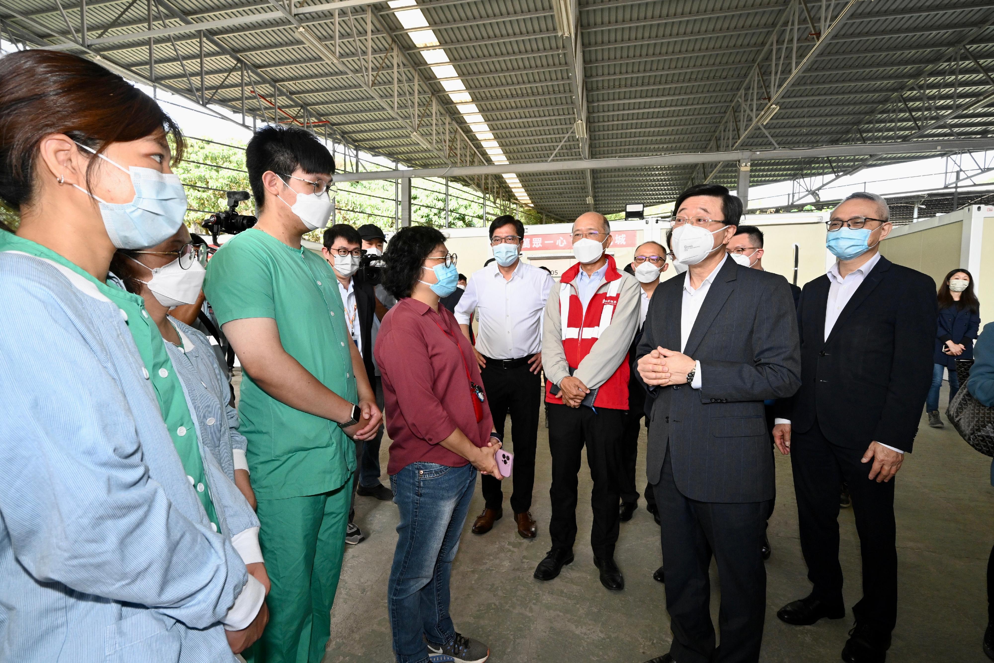 The Chief Secretary for Administration, Mr John Lee, this morning (March 17) visited the fifth community isolation facility constructed with Mainland support near Kai Pak Ling Road at Hung Shui Kiu in Yuen Long. Photo shows Mr Lee (second right) chatting with medical and nursing staff on-site. Looking on are the Secretary for Development, Mr Michael Wong (fifth right), and the Under Secretary for Food and Health, Dr Chui Tak-yi (first right).