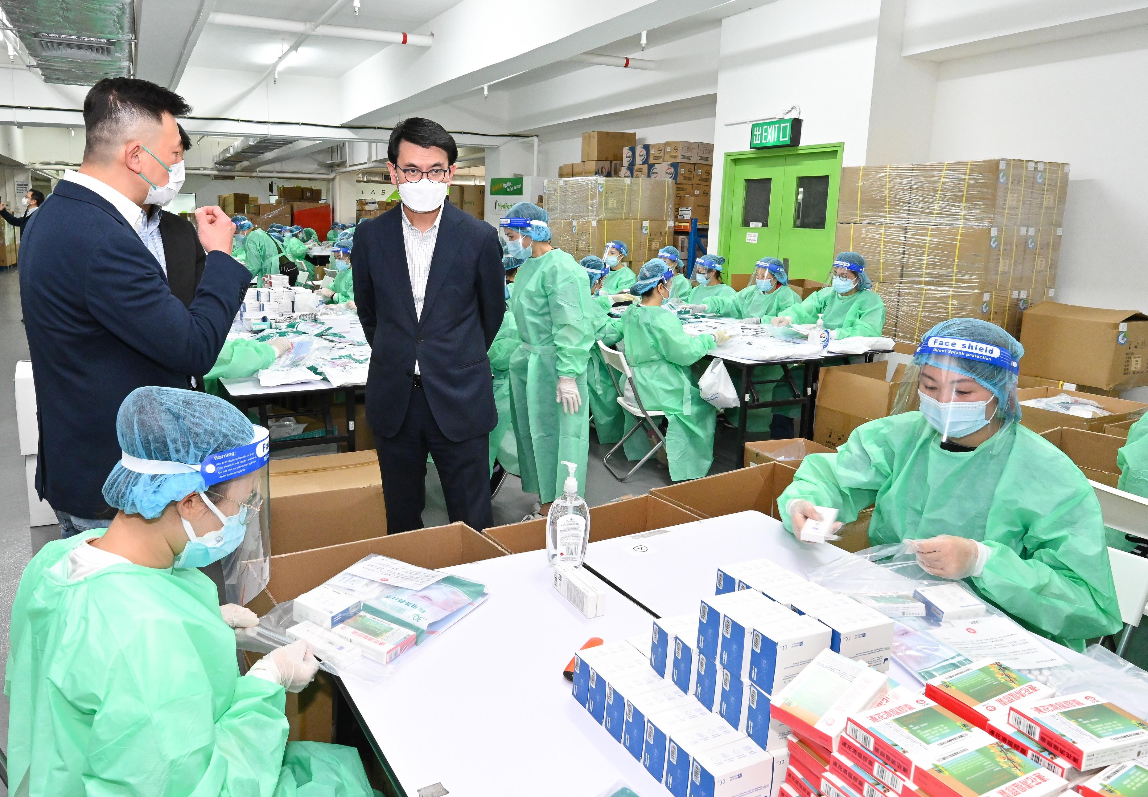 The Secretary for Commerce and Economic Development, Mr Edward Yau, today (March 17) visited a number of locations to learn about the logistics arrangements after the arrival of anti-epidemic medical supplies from the Mainland. Photo shows Mr Yau (second right), visiting a workshop commissioned by the Government for packing anti-epidemic kits.