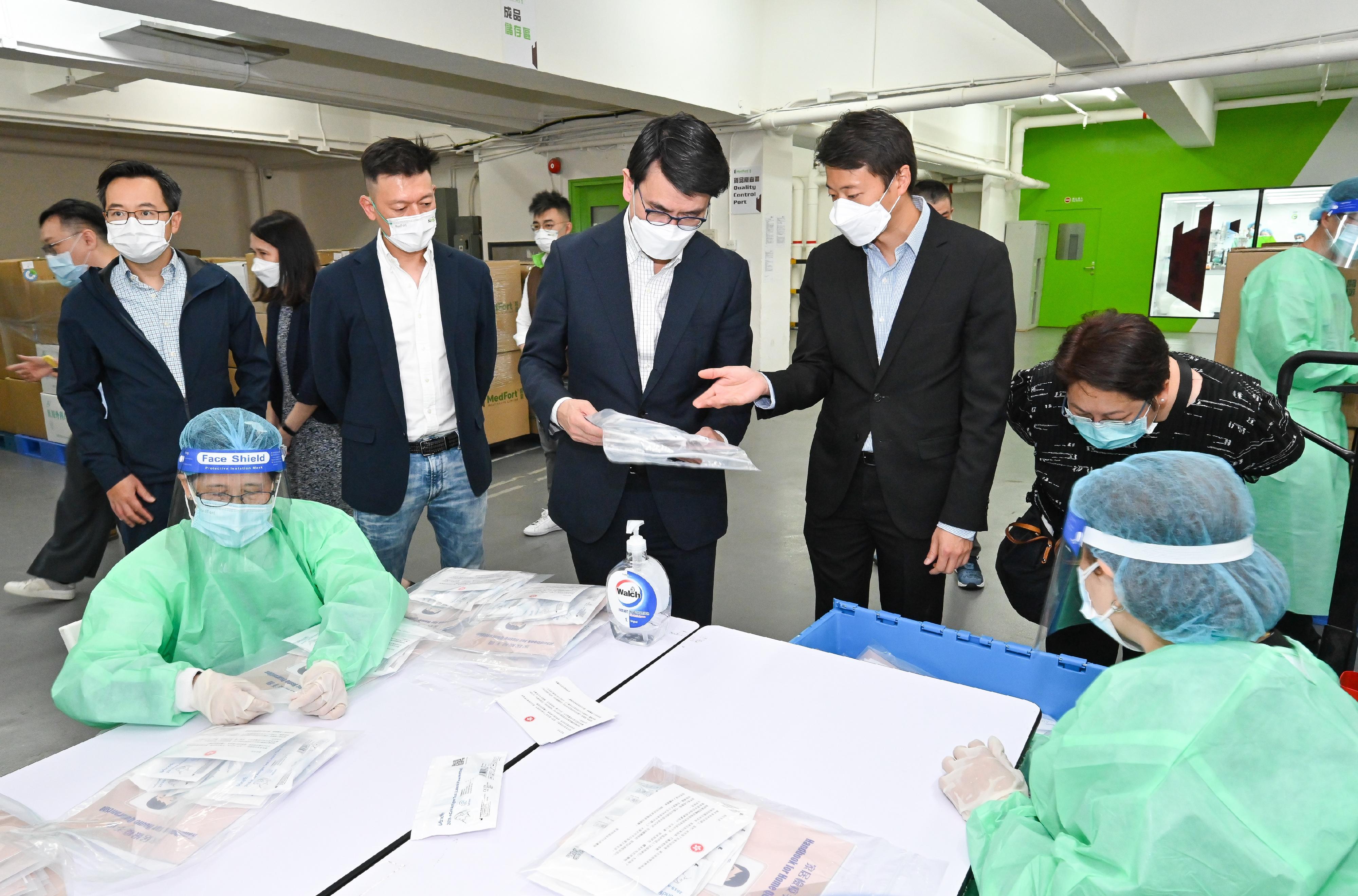 The Secretary for Commerce and Economic Development, Mr Edward Yau, today (March 17) visited a number of locations to learn about the logistics arrangements after the arrival of anti-epidemic medical supplies from the Mainland. Photo shows Mr Yau (fifth right), visiting a workshop commissioned by the Government for packing anti-epidemic kits.