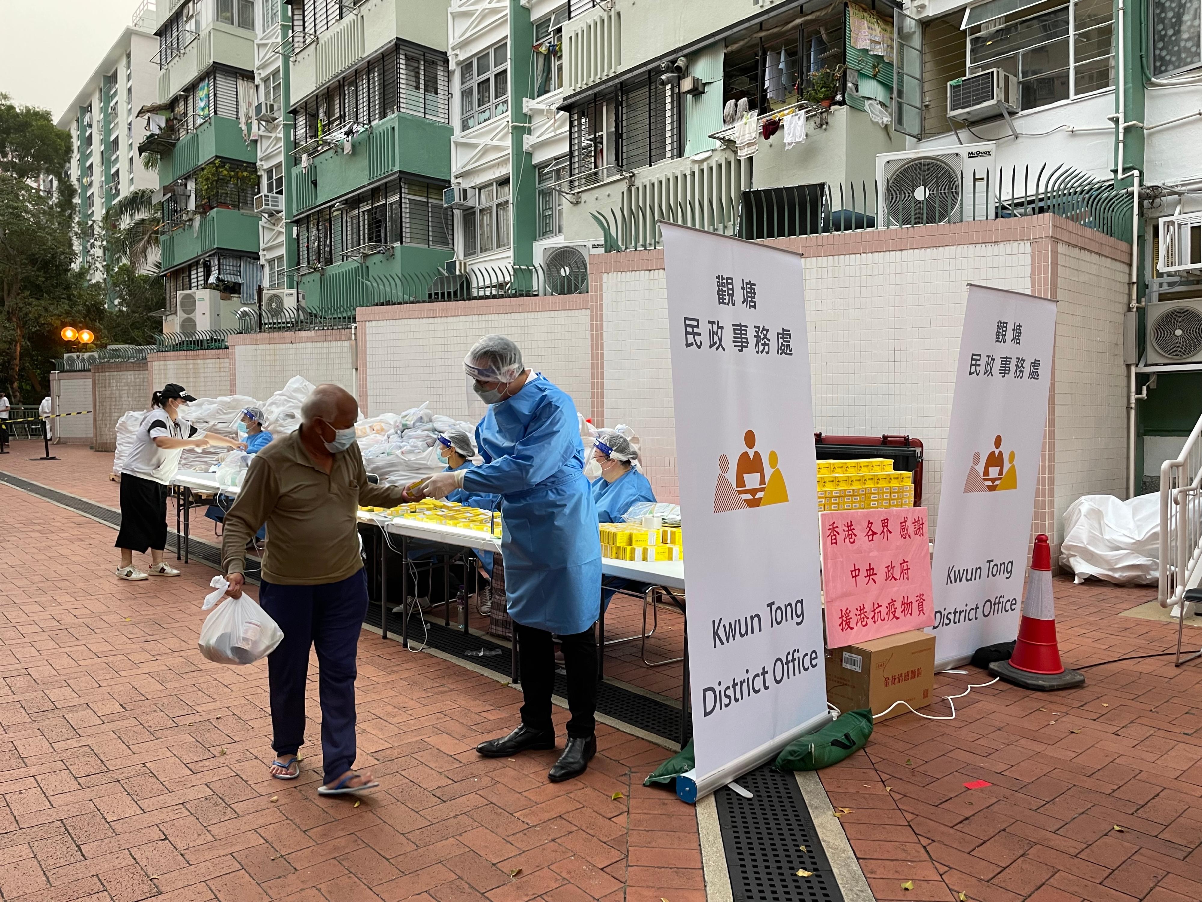 The Government yesterday (March 18) made a "restriction-testing declaration" and issued a compulsory testing notice in respect of the specified "restricted area" in Kwun Tong (i.e. Ping On House, Tai On House and Yee On House, Wo Lok Estate, Kwun Tong, excluding units 1-14 and Wo Lok Estate Office on G/F.), under which people within the specified "restricted area" in Kwun Tong were required to stay in their premises and undergo compulsory testing. Photo shows the District Officer (Kwun Tong), Mr Steve Tse, distributing anti-epidemic proprietary Chinese medicines supplied by the Central People's Government to a person subject to compulsory testing in the "restricted area".