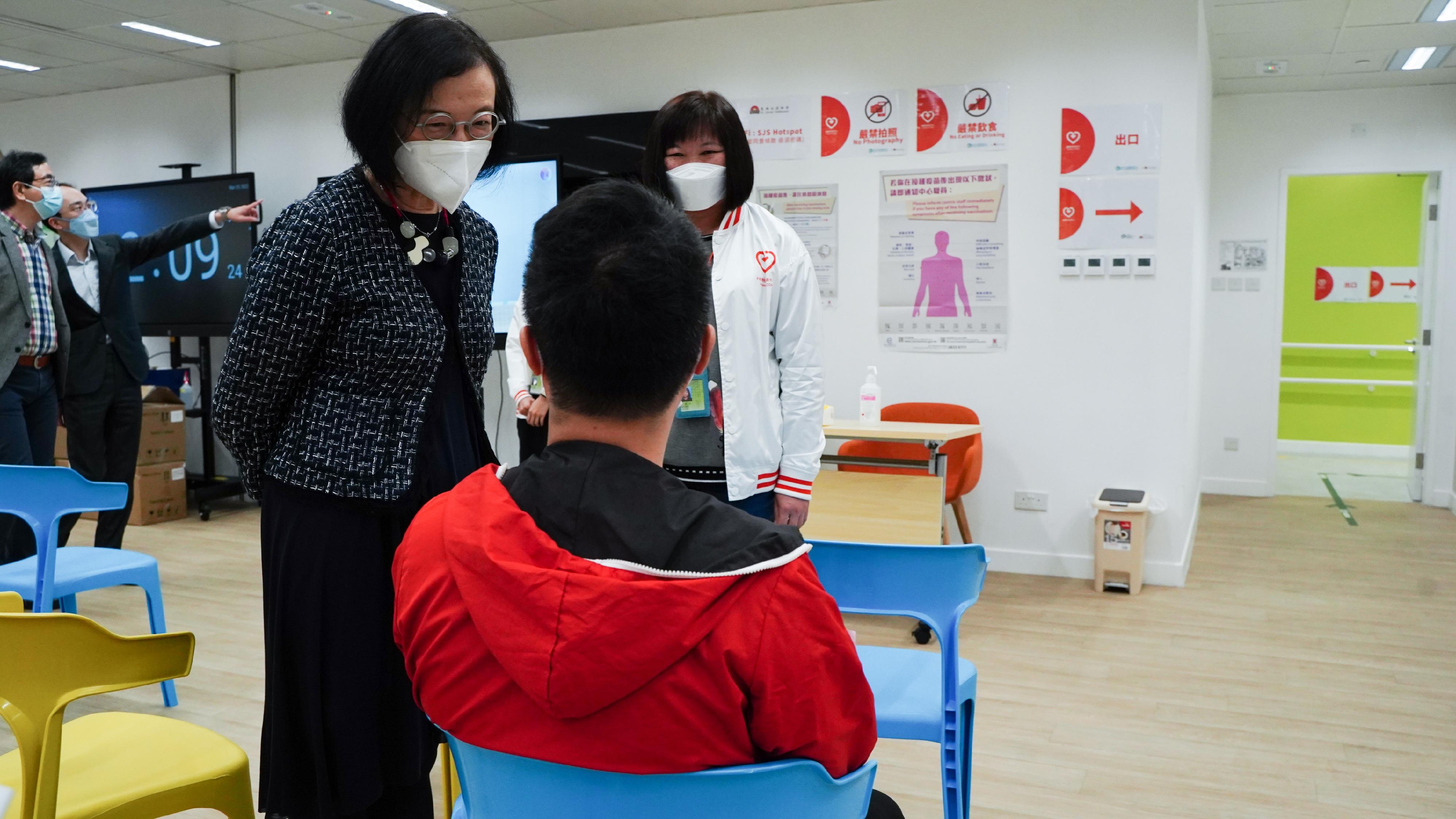 The Secretary for Food and Health, Professor Sophia Chan, visited Sham Shui Po District Health Centre today (March 25) to learn more about the provision of the BioNTech vaccination service there. Photo shows Professor Chan (left) chatting with a citizen getting a jab there.