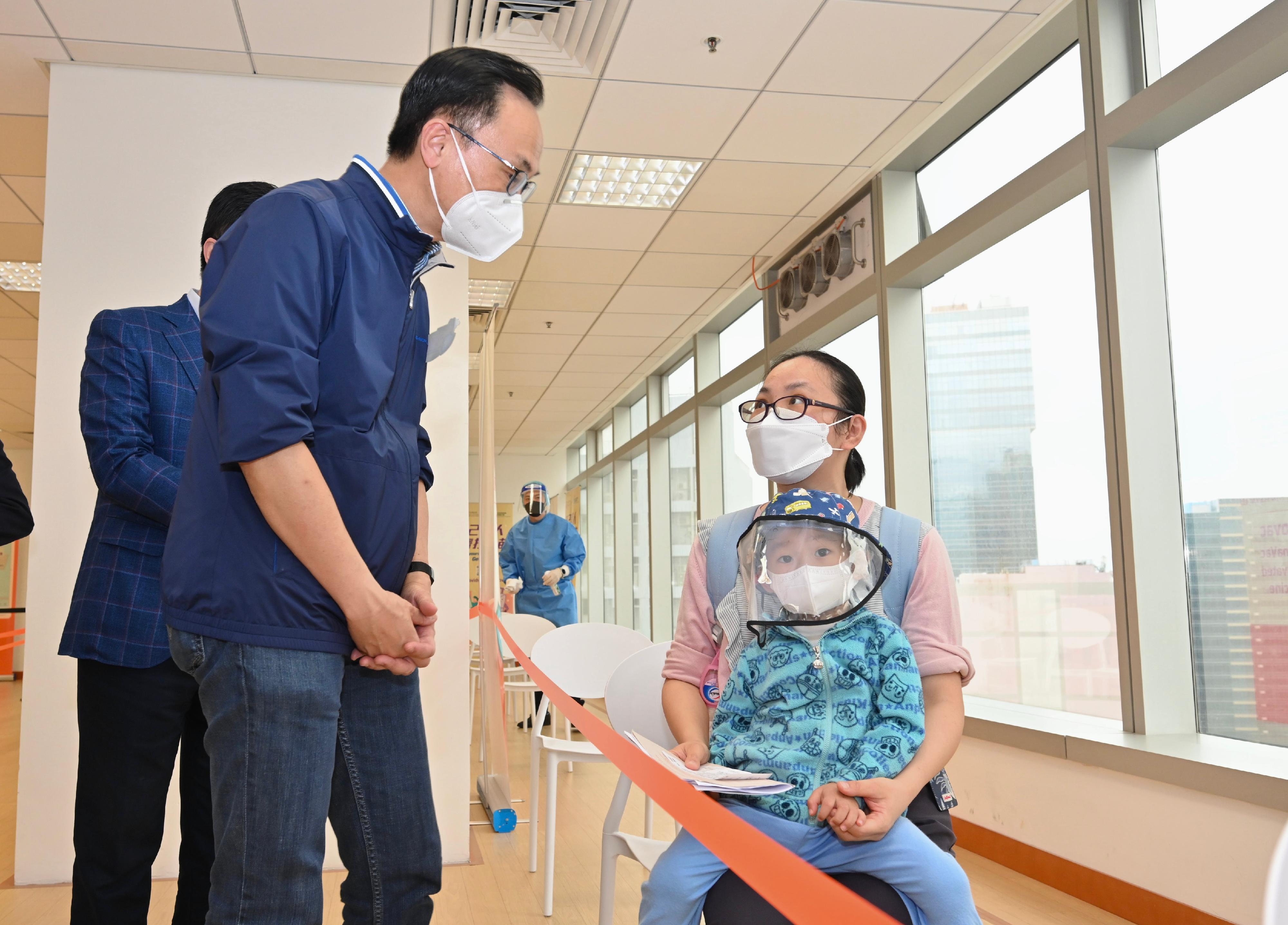 The Secretary for the Civil Service, Mr Patrick Nip, today (March 26) inspected the operation of the Millennium City 5 Community Vaccination Centre (CVC) in Kwun Tong. Photo shows Mr Nip (left) chatting with a parent whose child to receive vaccination there.


