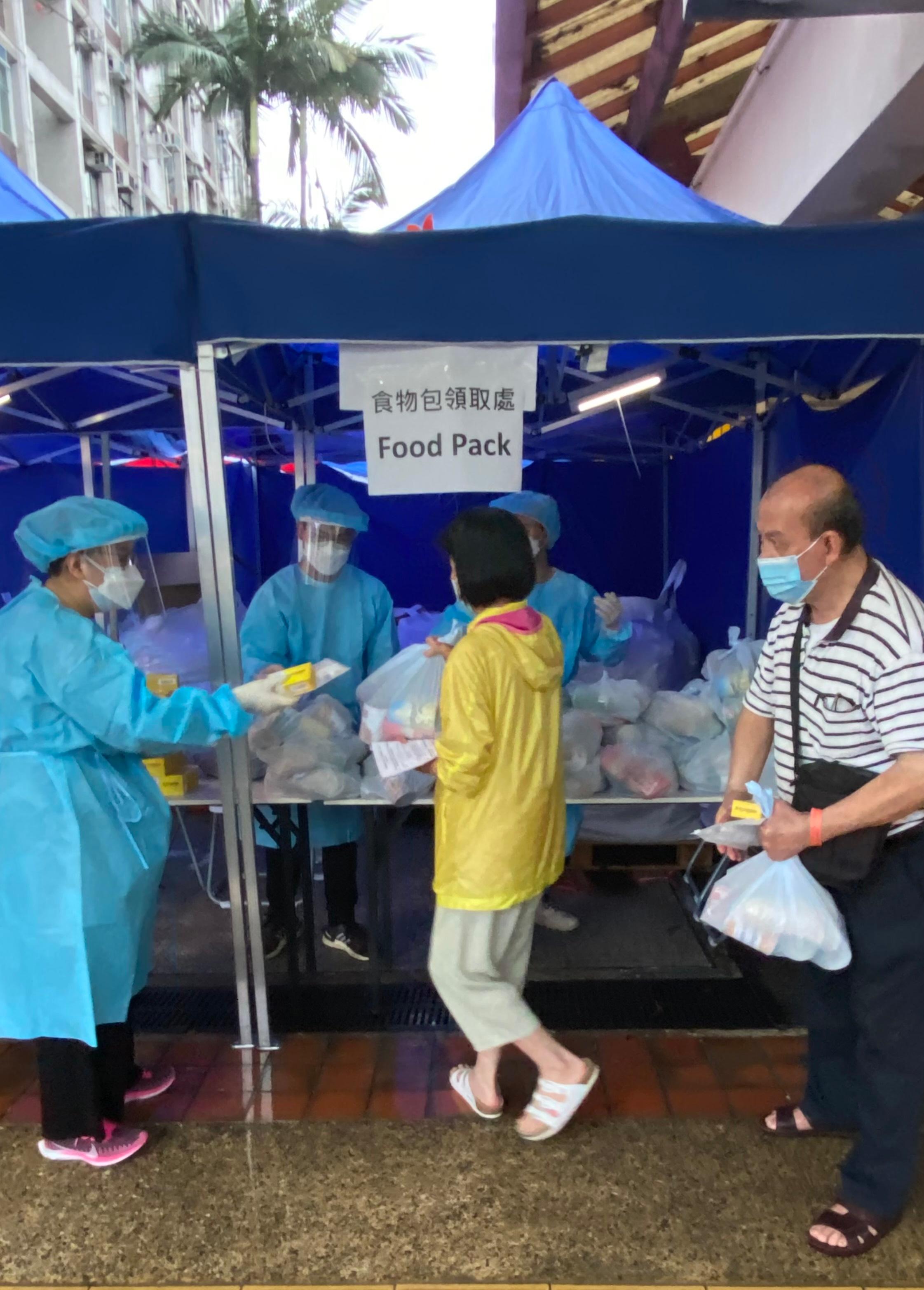 The Government yesterday (March 25) enforced "restriction-testing declaration" and compulsory testing notice in respect of specified "restricted area" in Cheung Tung House, Tung Tau (II) Estate, Wong Tai Sin. Photo shows staff members of the Inland Revenue Department distributing food packs to persons subject to compulsory testing.