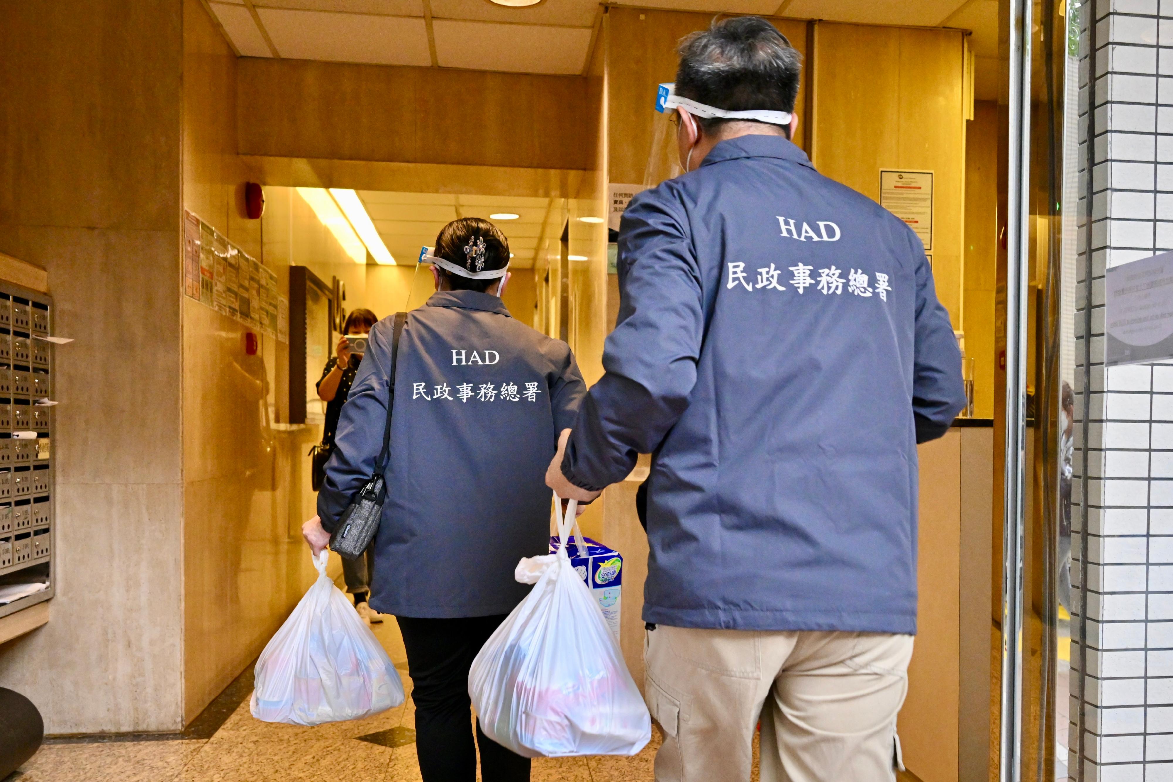 The Acting Director of Home Affairs, Miss Vega Wong, together with the "Special Caring Delivery Team" formed by civil servants, delivered food and basic daily necessities to families in need in the Hong Kong East District on March 26. Photo shows Miss Wong (left) joining the delivery service with a civil servant.