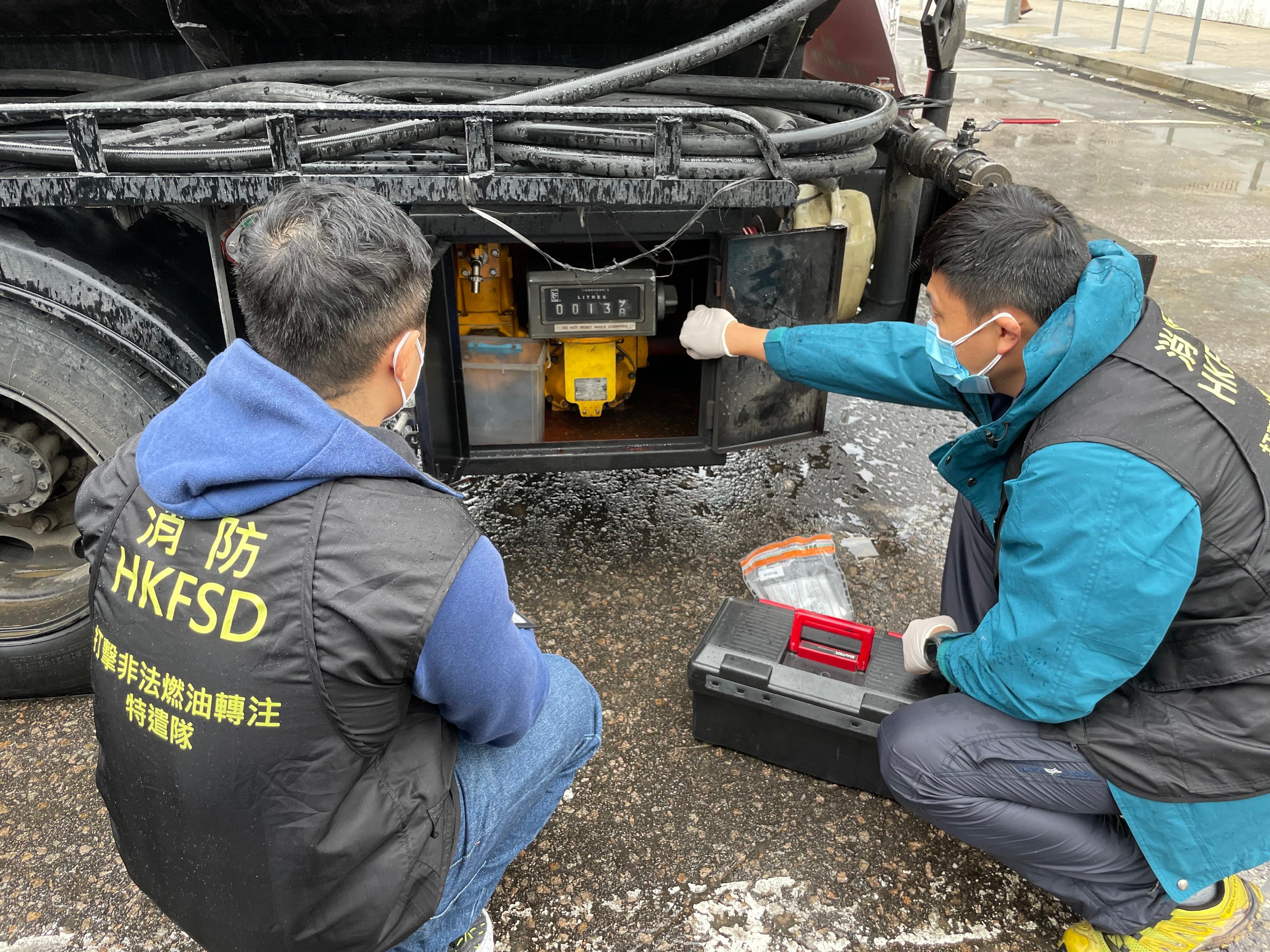 The Fire Services Department (FSD) and the Hong Kong Police Force mounted a joint operation to combat illicit fuelling activities today (March 28). Photo shows FSD law enforcement officers inspecting a dangerous goods vehicle suspected to be involved in the illicit fuelling activity during the joint operation.