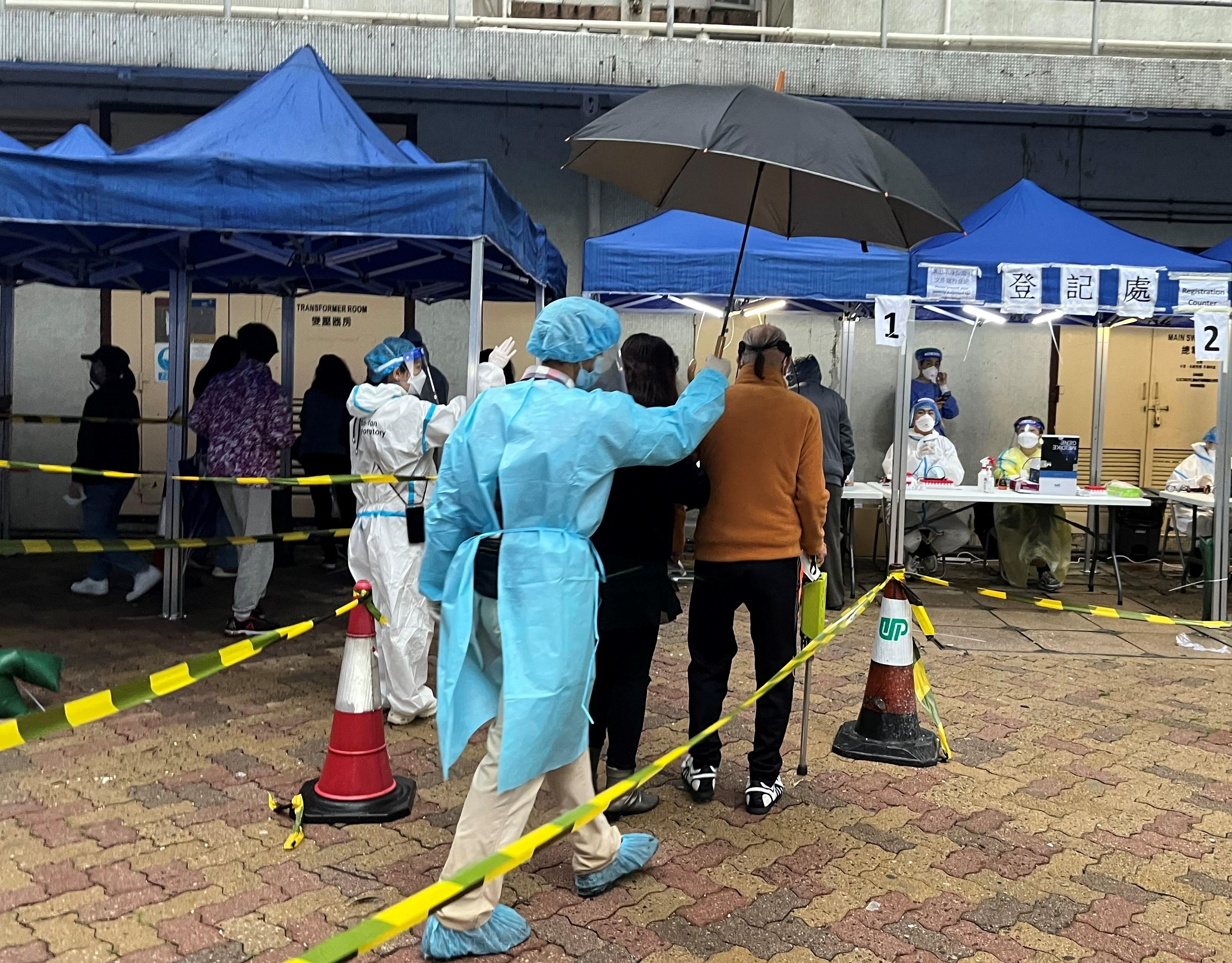 The Government yesterday (March 28) enforced "restriction-testing declaration" and compulsory testing notice in respect of specified "restricted area" in Cheung Chi House, Cheung Wah Estate, Fanling. Photo shows staff members of the Agriculture, Fisheries and Conservation Department guiding residents subject to compulsory testing to specimen collection stations in batches to undergo a nucleic acid test.
