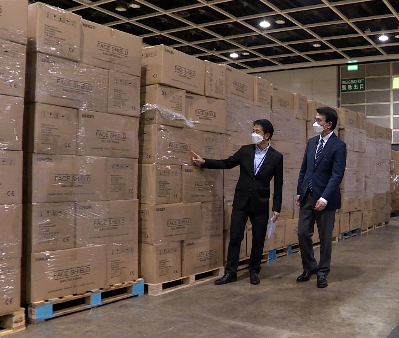 The Secretary for Commerce and Economic Development, Mr Edward Yau (right), and the Permanent Secretary for Commerce and Economic Development (Communications and Creative Industries), Mr Clement Leung, visit the Hong Kong Convention and Exhibition Centre. This is one of the places temporarily used by the Government for storage and logistics distribution of anti-epidemic medical supplies delivered to Hong Kong.