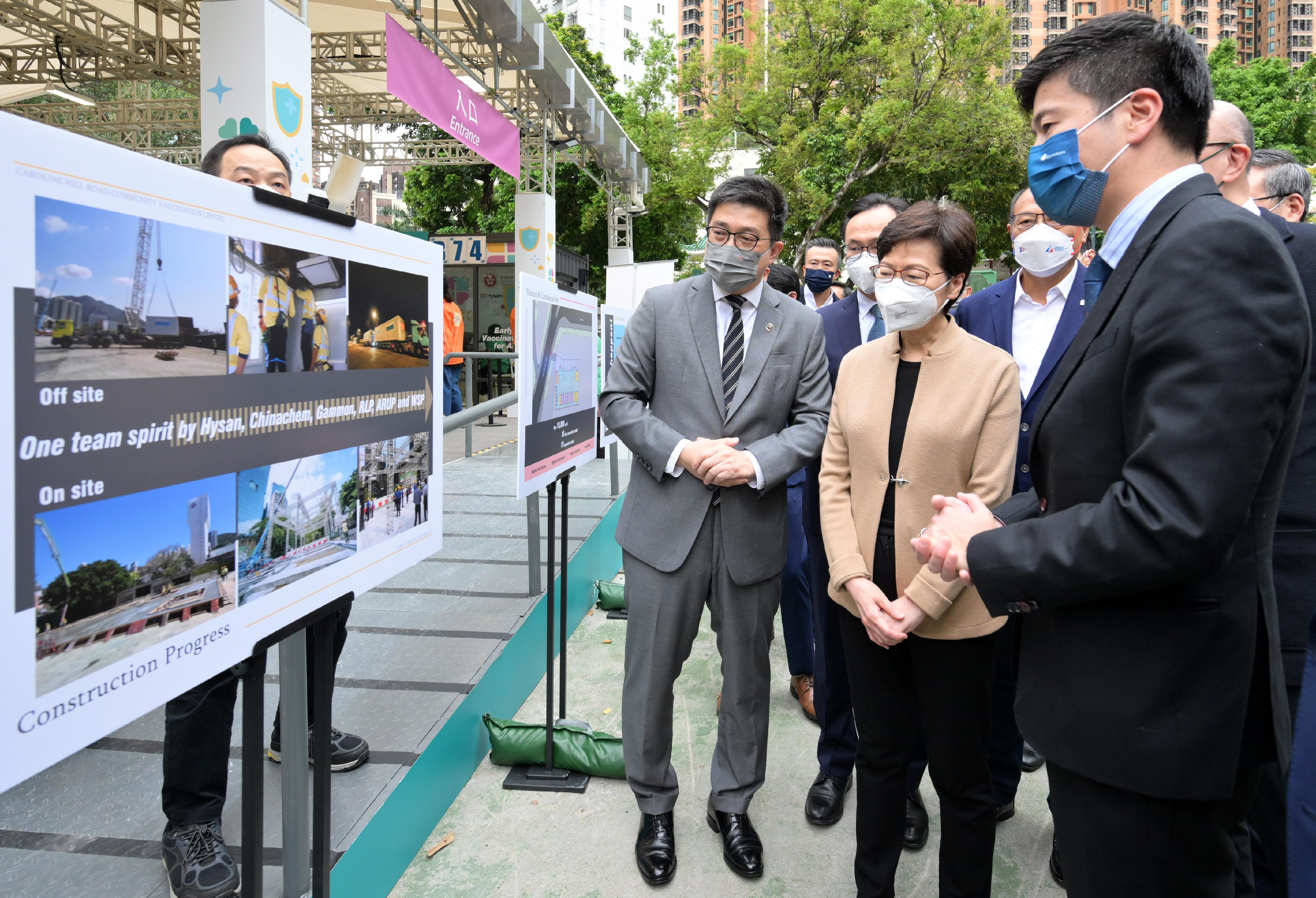The Chief Executive, Mrs Carrie Lam, visited the Caroline Hill Road Pop-up Community Vaccination Centre today (March 29). Photo shows Mrs Lam (front, centre) being briefed by the Executive Director and Chief Operating Officer of Hysan Development, Mr Ricky Lui (front, left), on the operation of the centre.